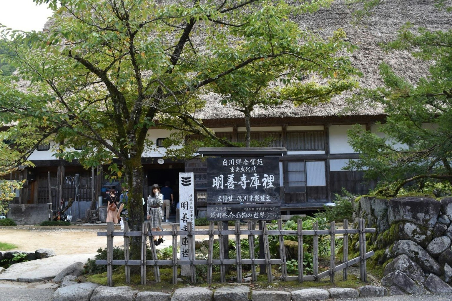 Maison japonaise traditionnelle avec toit de chaume et vue sur le jardin clôture en bois