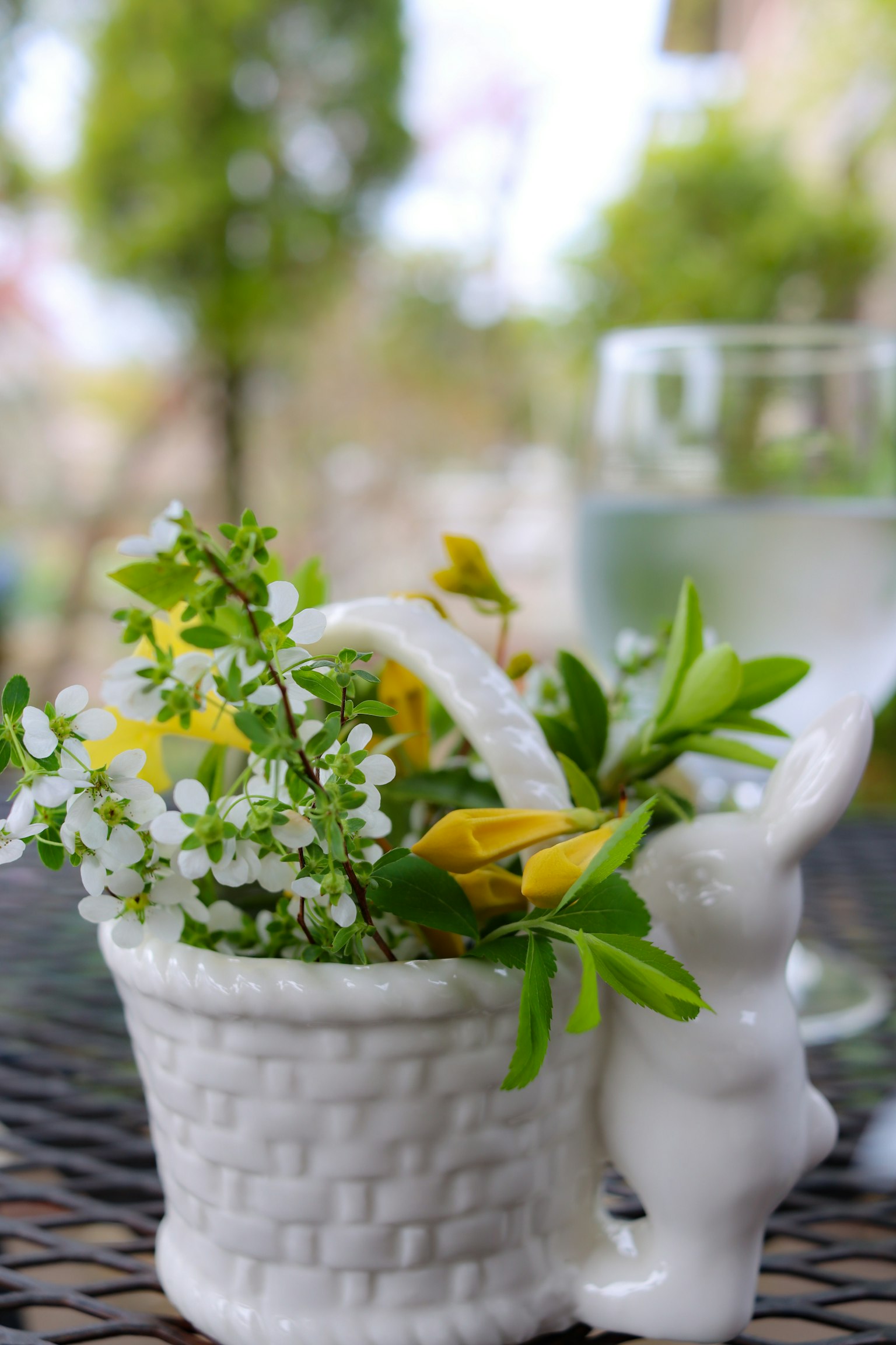 Ein weißer, kaninchenförmiger Blumenkorb, gefüllt mit bunten Blumen