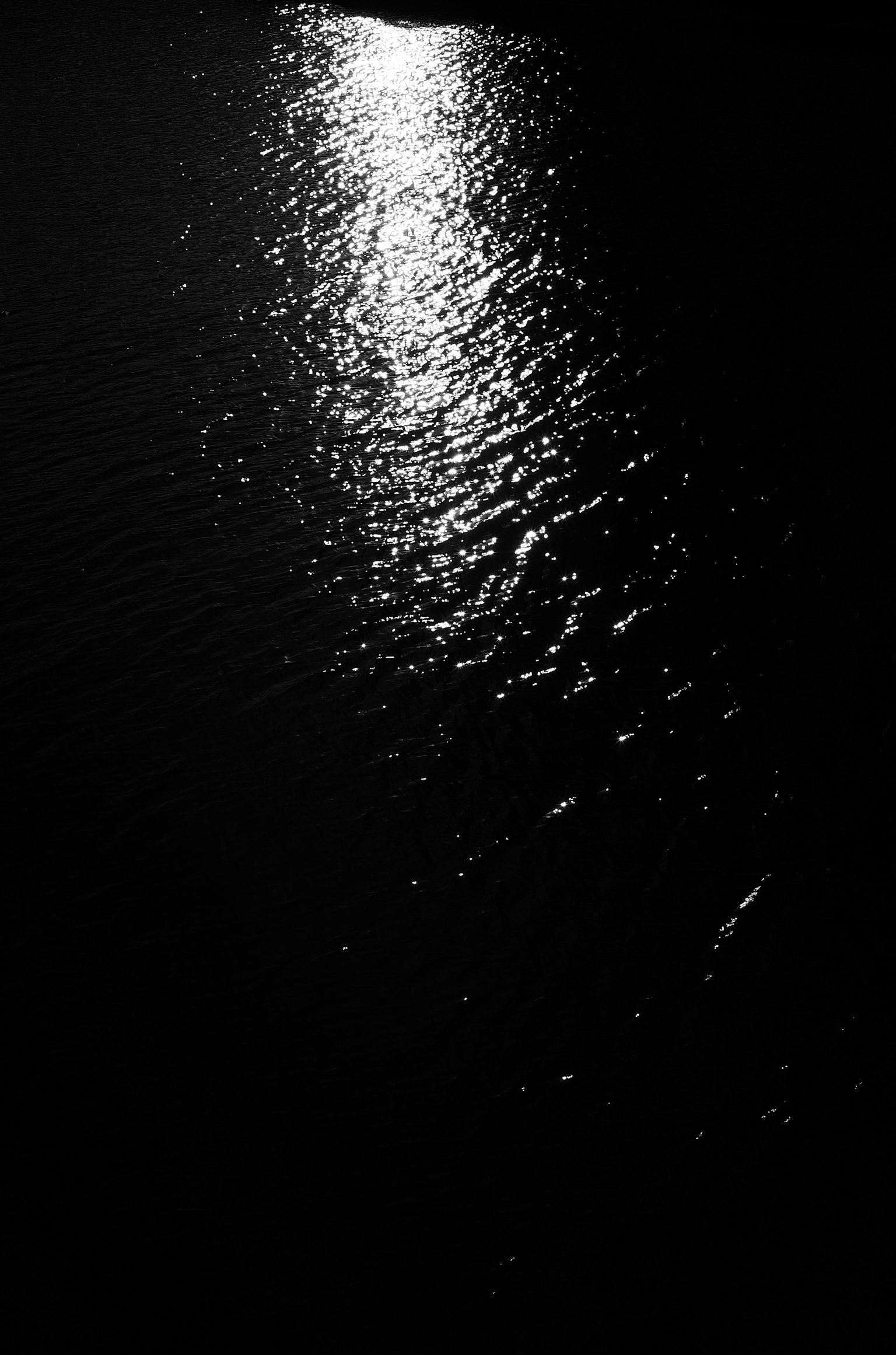Luz reflejándose en la superficie oscura del agua creando ondas