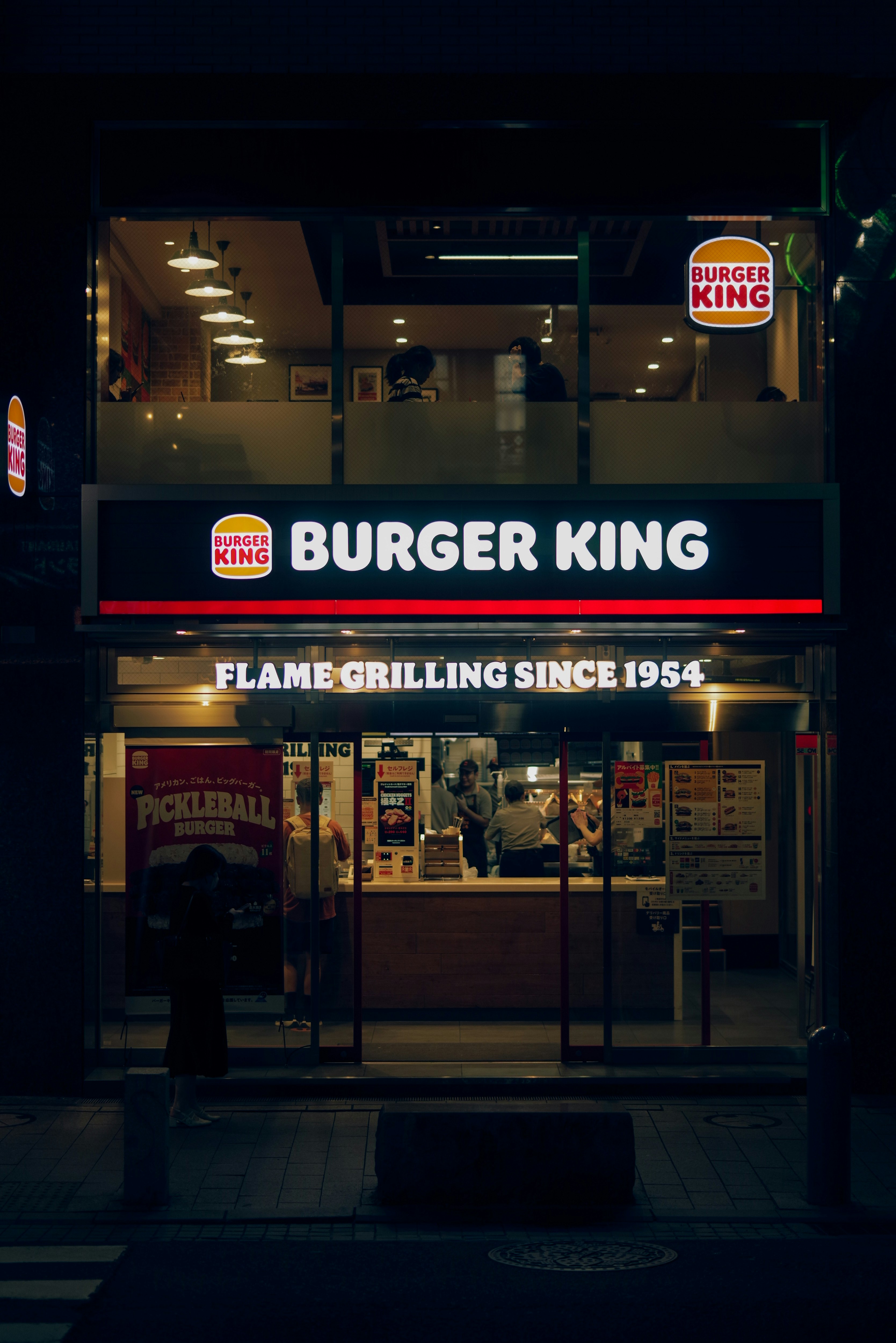 night exterior of a fast-food restaurant with neon signage
