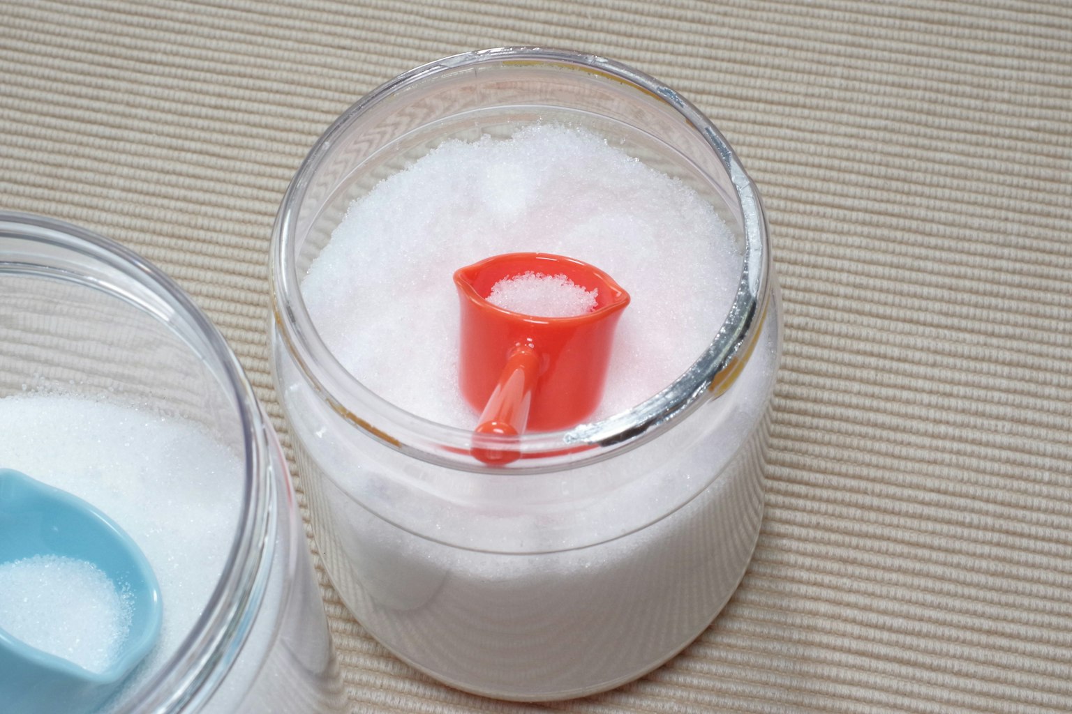 Bình trong suốt chứa bột trắng và thìa đỏ