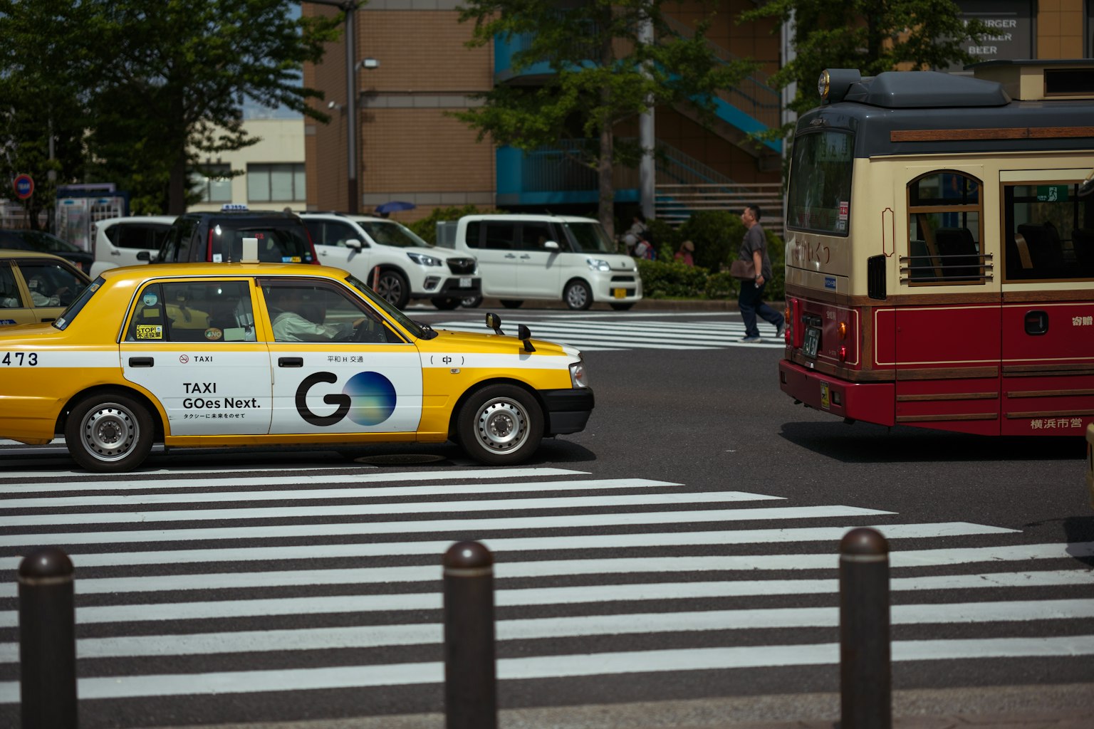 Taxi màu vàng và xe buýt cổ điển tại vạch qua đường ở khu vực đô thị nhộn nhịp