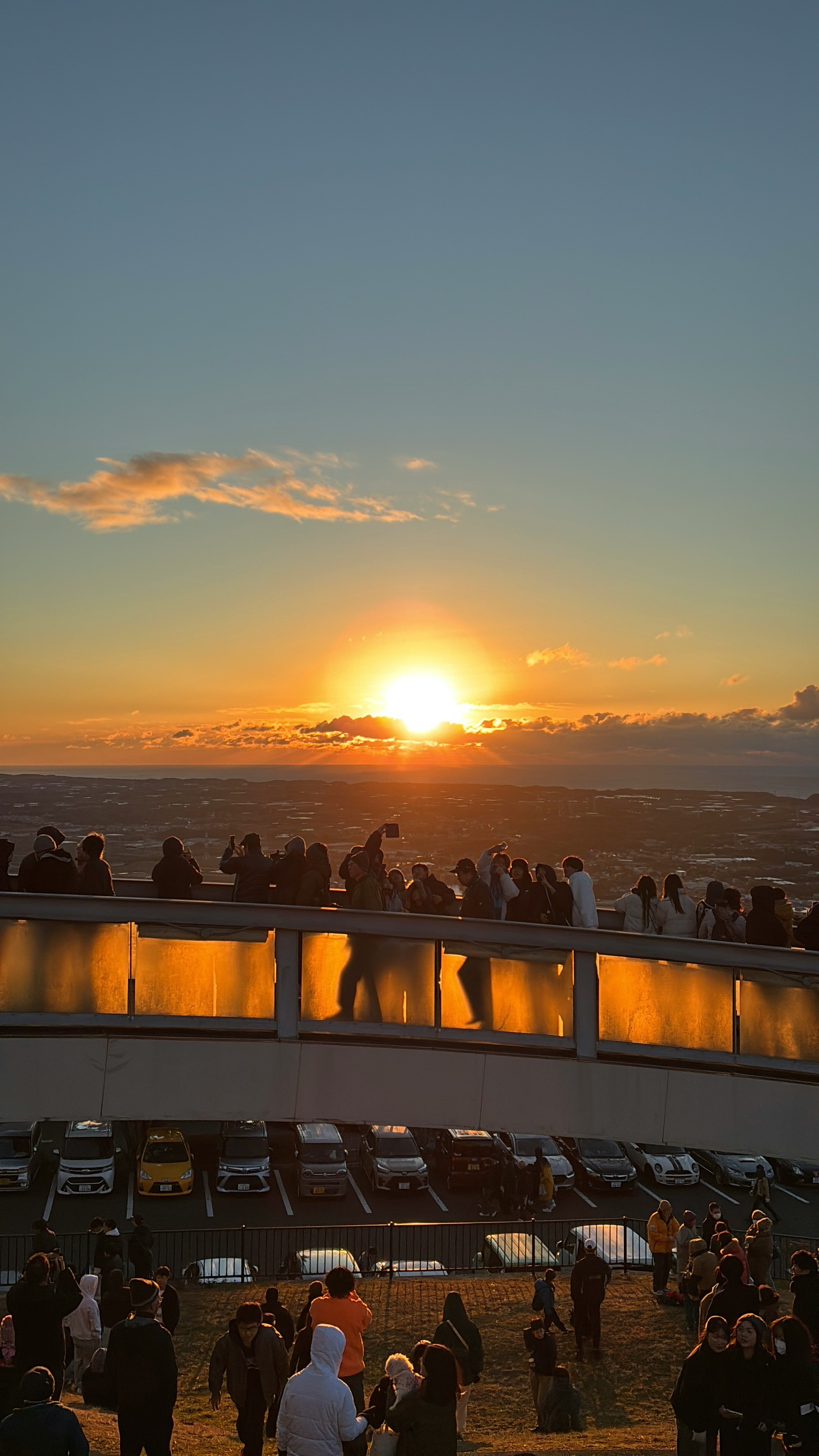 初日の出を見上げる人々と海辺の夕焼けの空