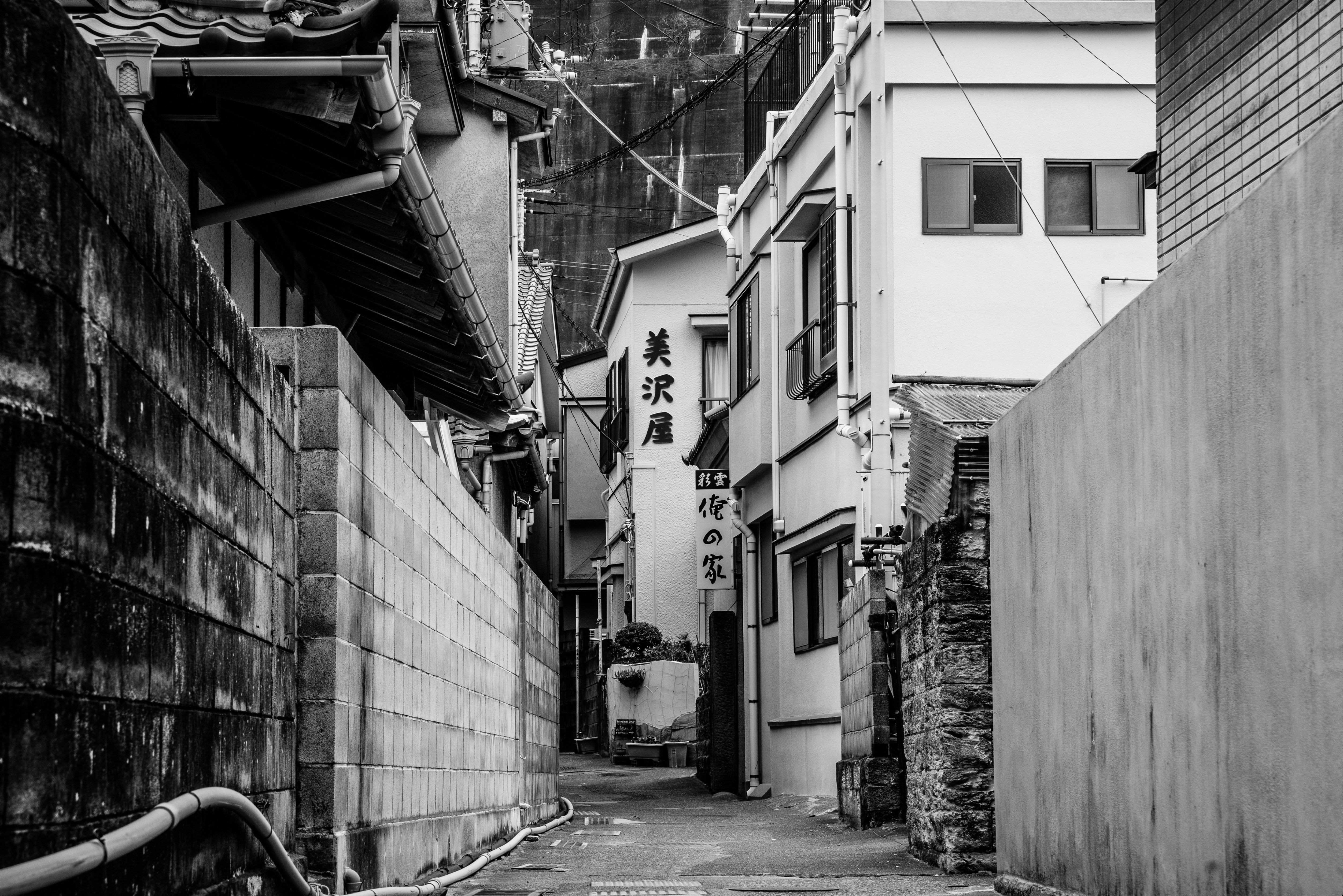 narrow alley with buildings and a hanging sign