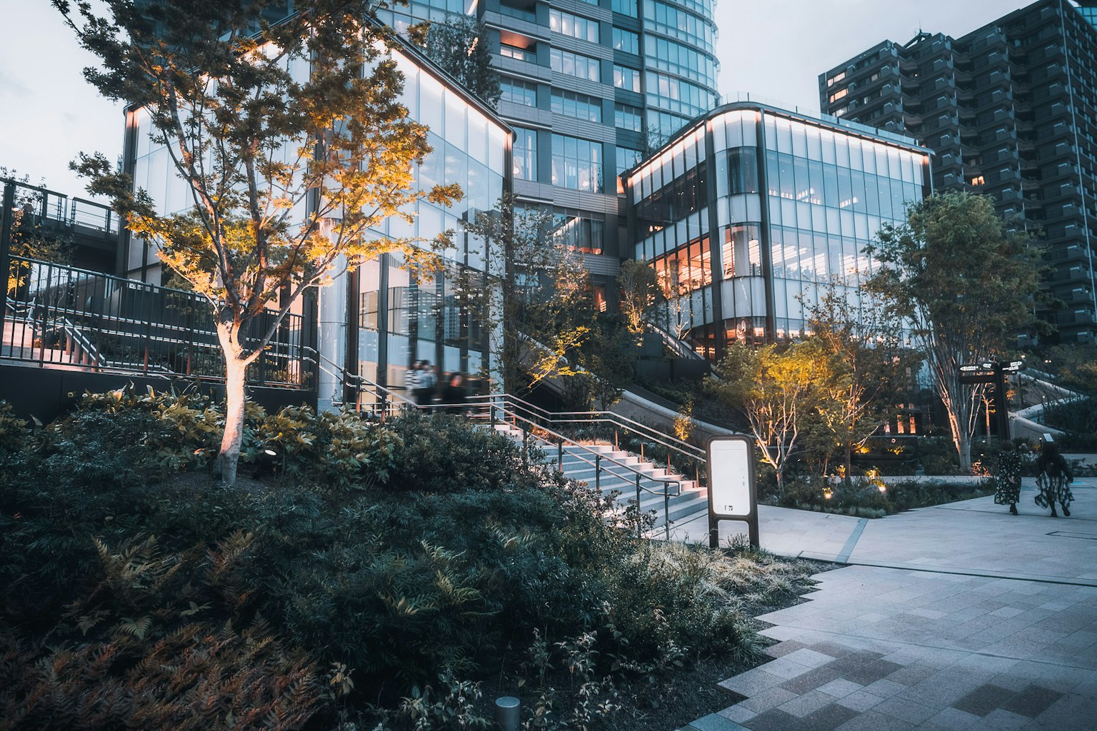 Modern building with glass facade surrounded by greenery and urban landscape