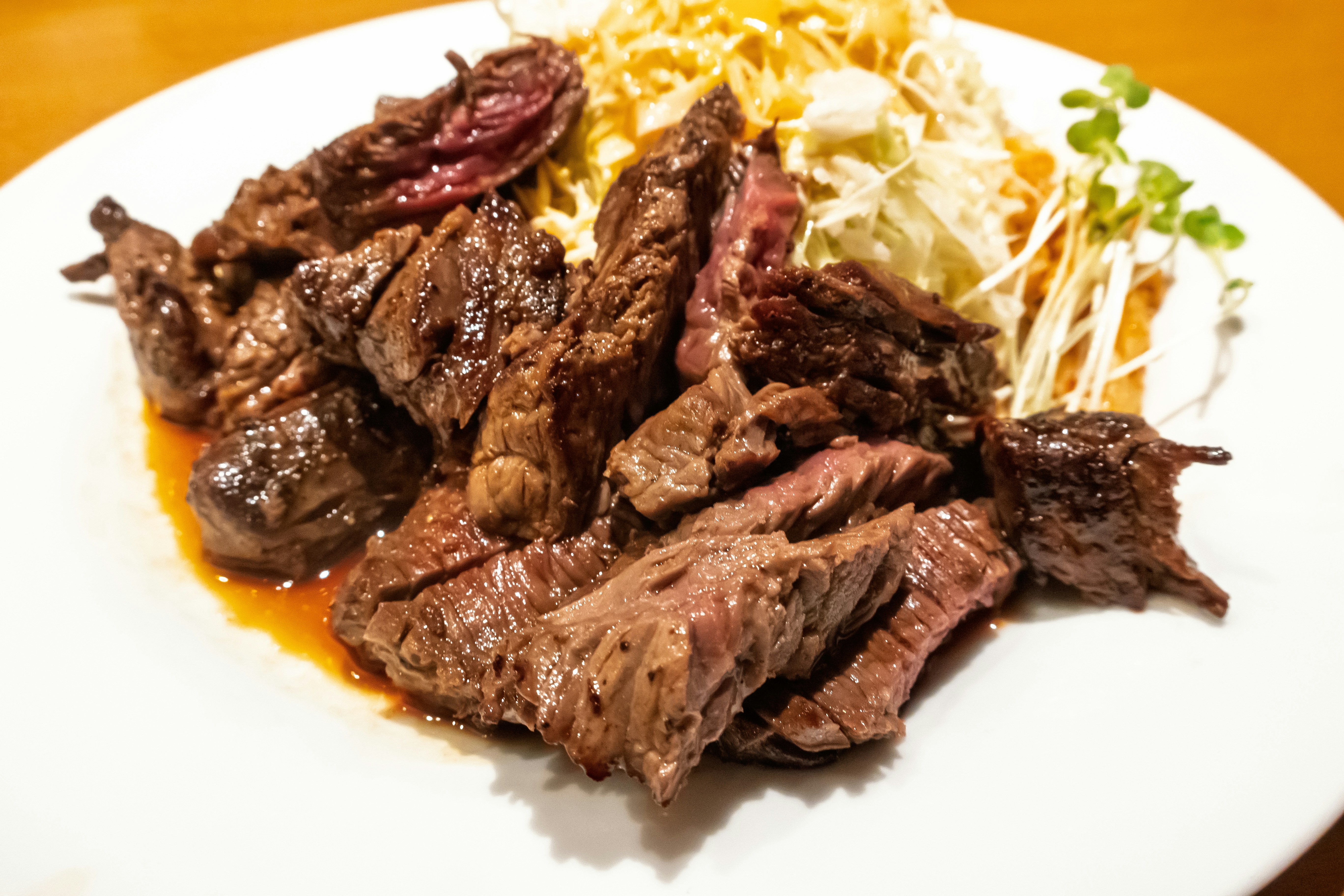 オレンジソースの上に盛られた肉料理と豆もやし