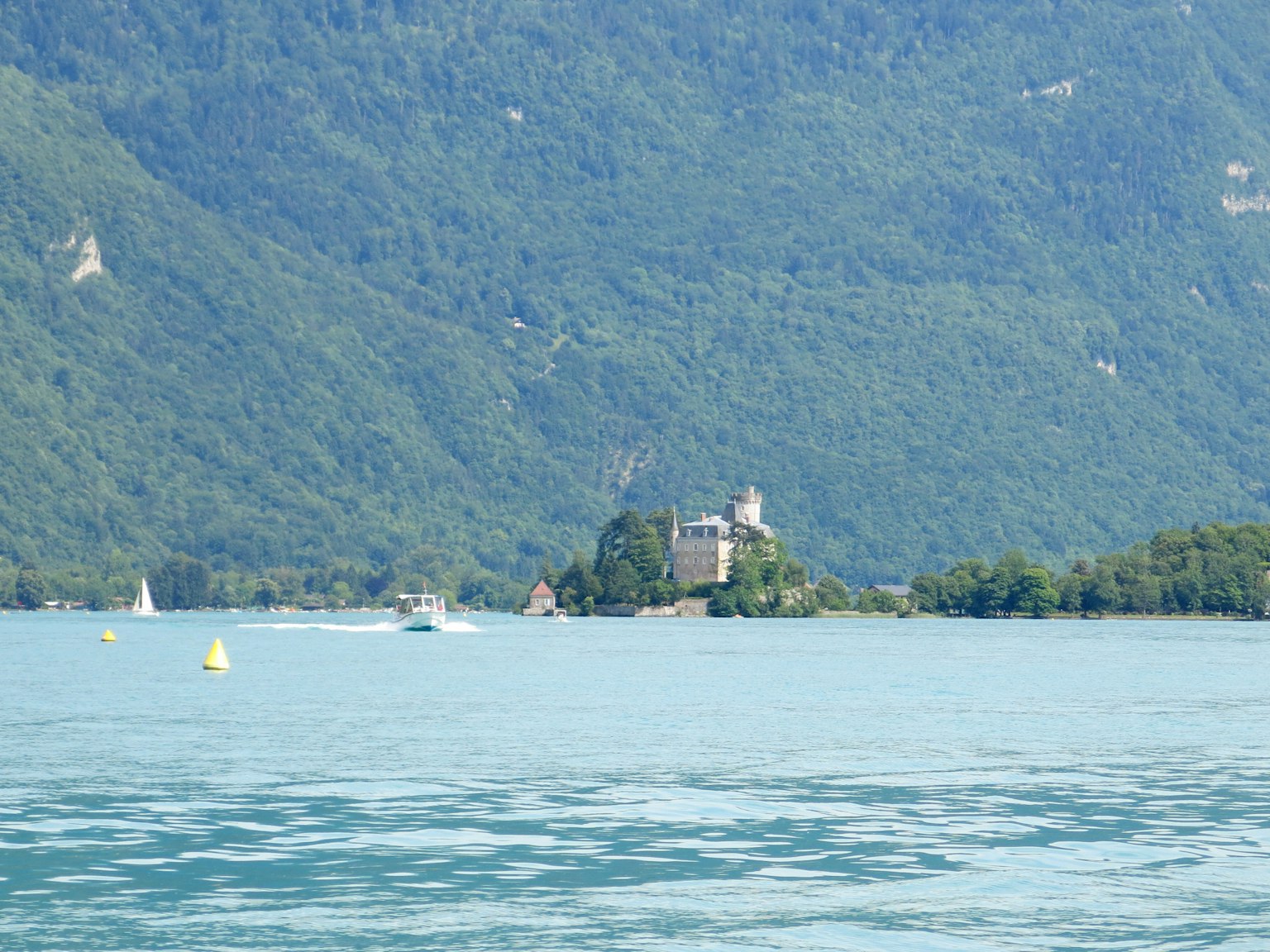 Ein malerisches Schloss auf einer Insel umgeben von einem ruhigen See und üppigen Bergen