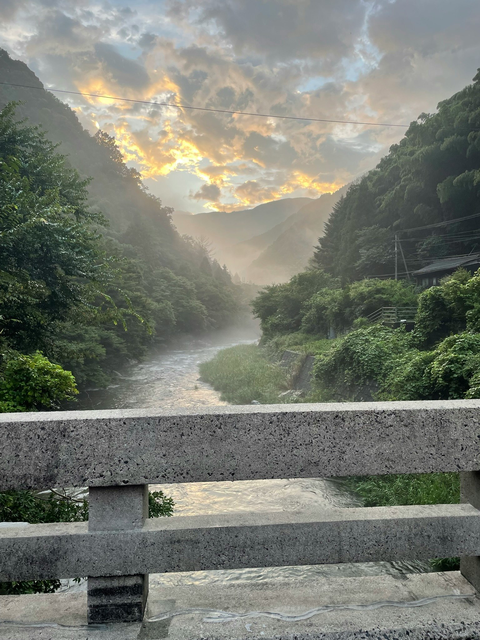 日落時河流周圍被山脈環繞的風景