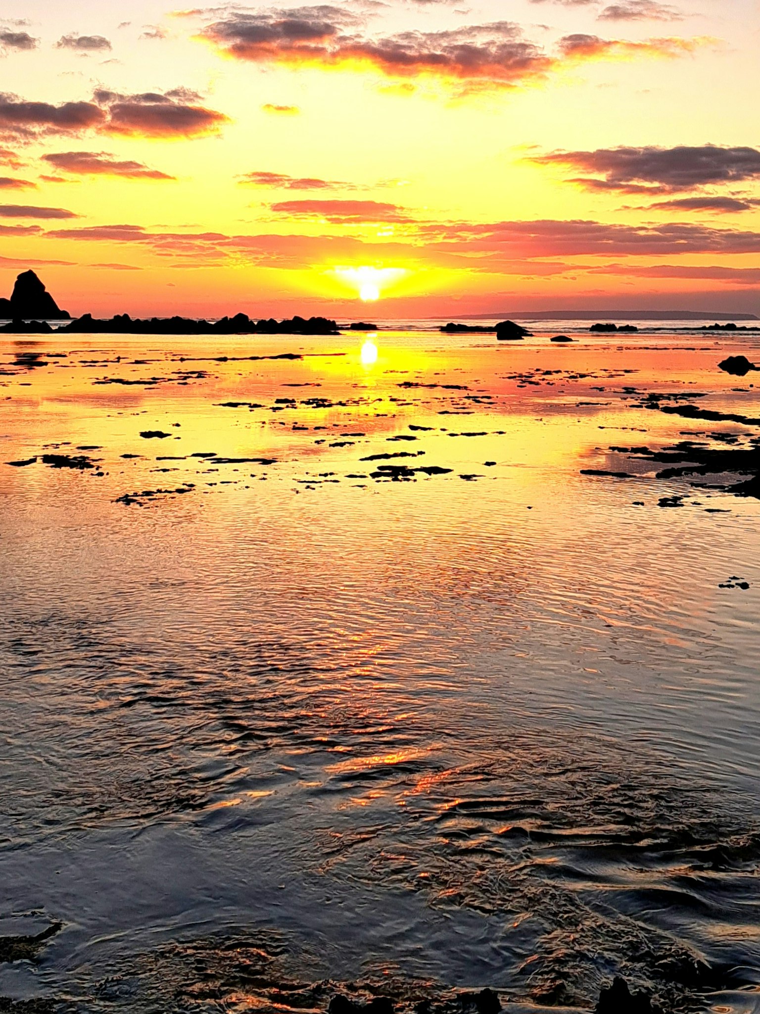 Schöner Sonnenuntergang über dem Ozean mit Reflexionen des orangefarbenen Himmels