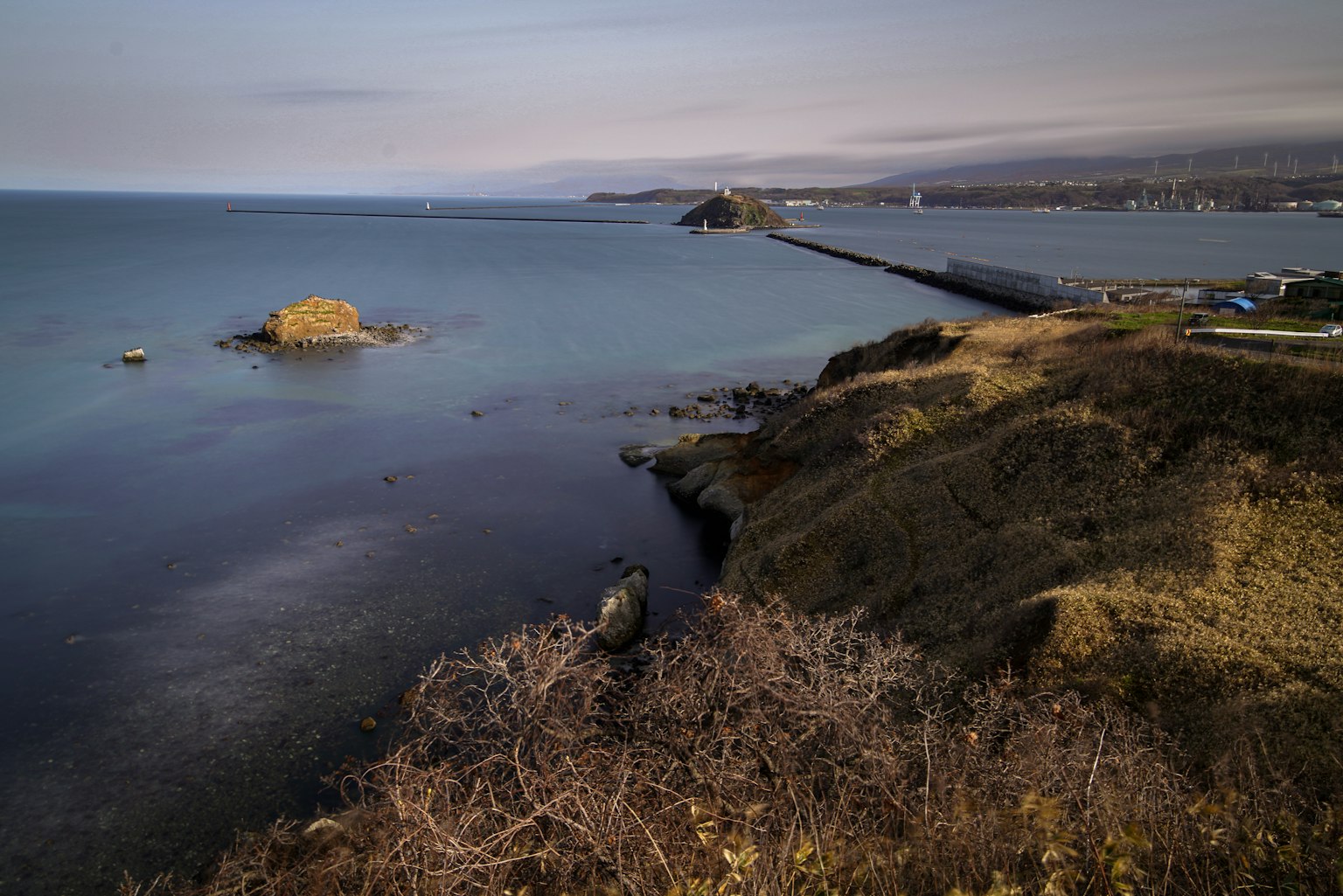 Coastal landscape with a small island at dusk calm sea