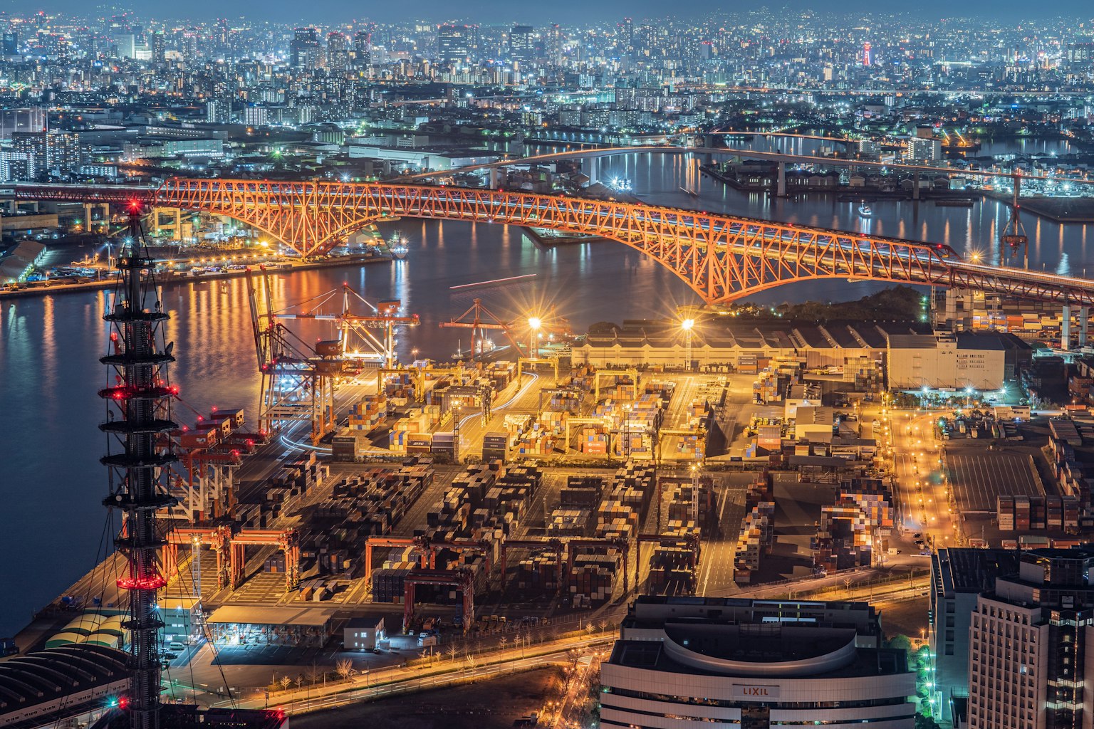 Vue aérienne d'un port avec un pont illuminé la nuit
