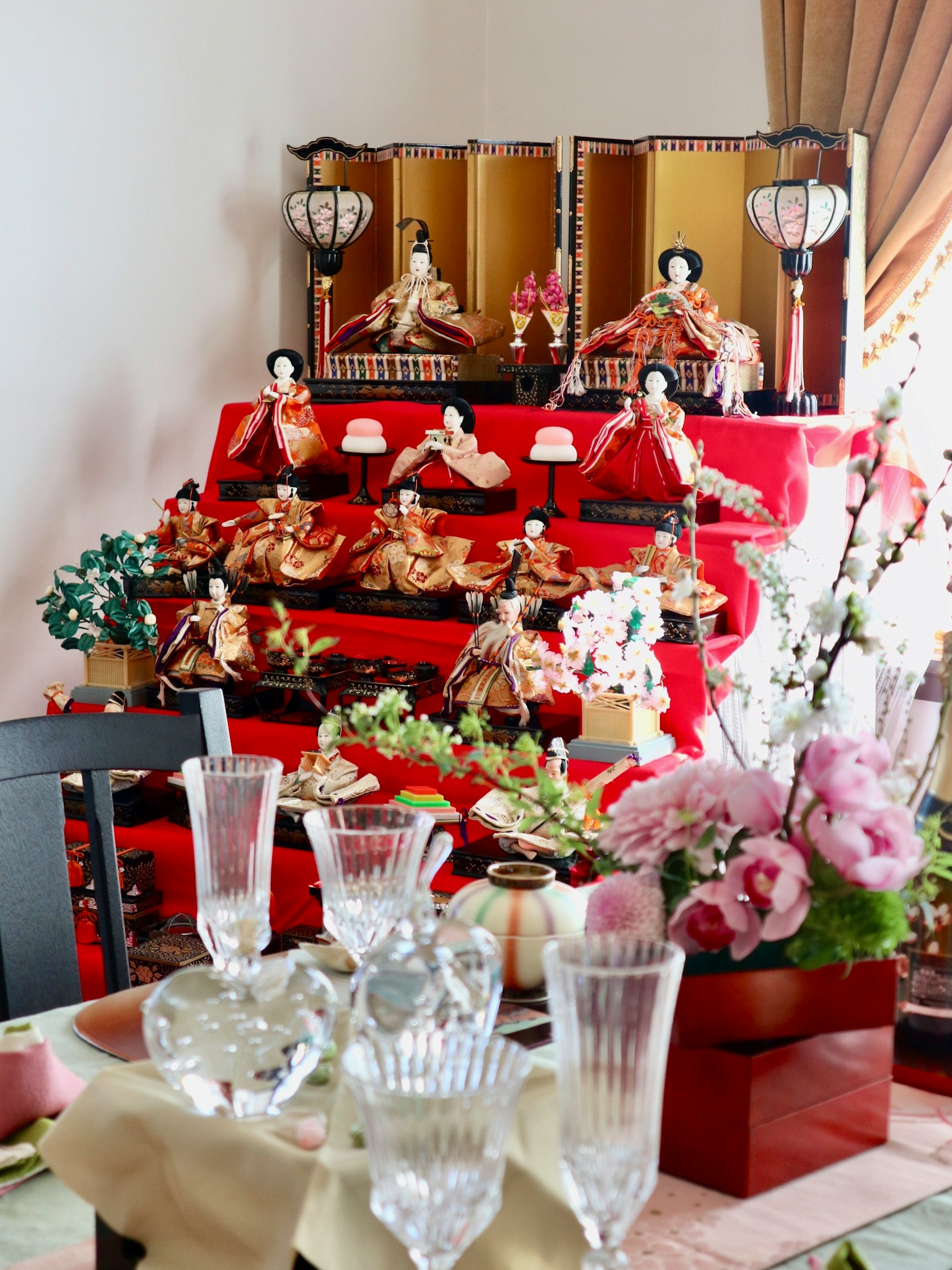Esposizione di bambole Hina per il festival Hinamatsuri con fiori sul tavolo