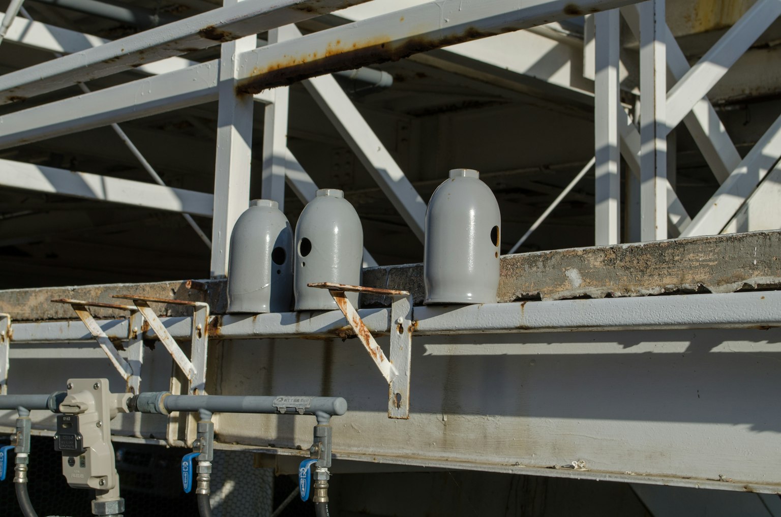 Botellas industriales grises colocadas sobre una estructura metálica