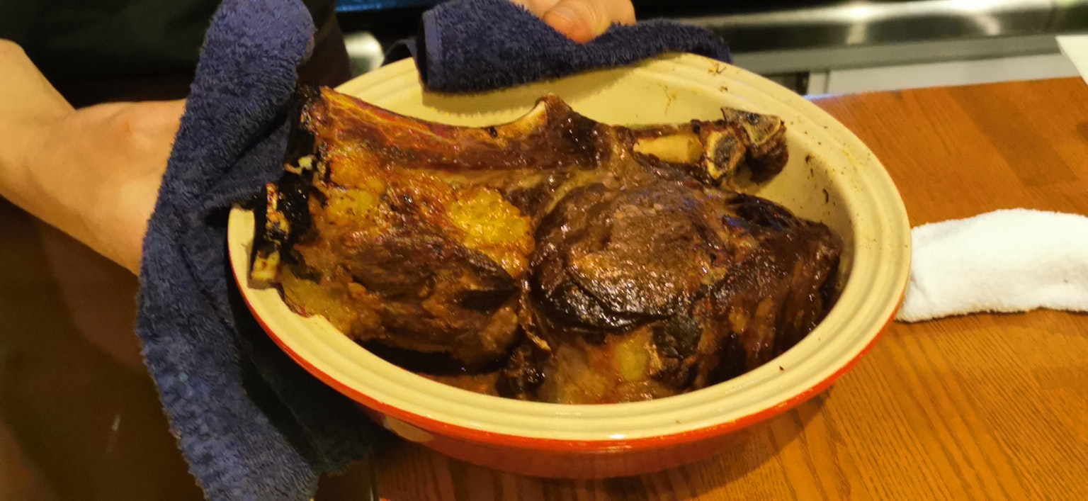 Un plat de viande rôtie tenu à la main avec une croûte dorée