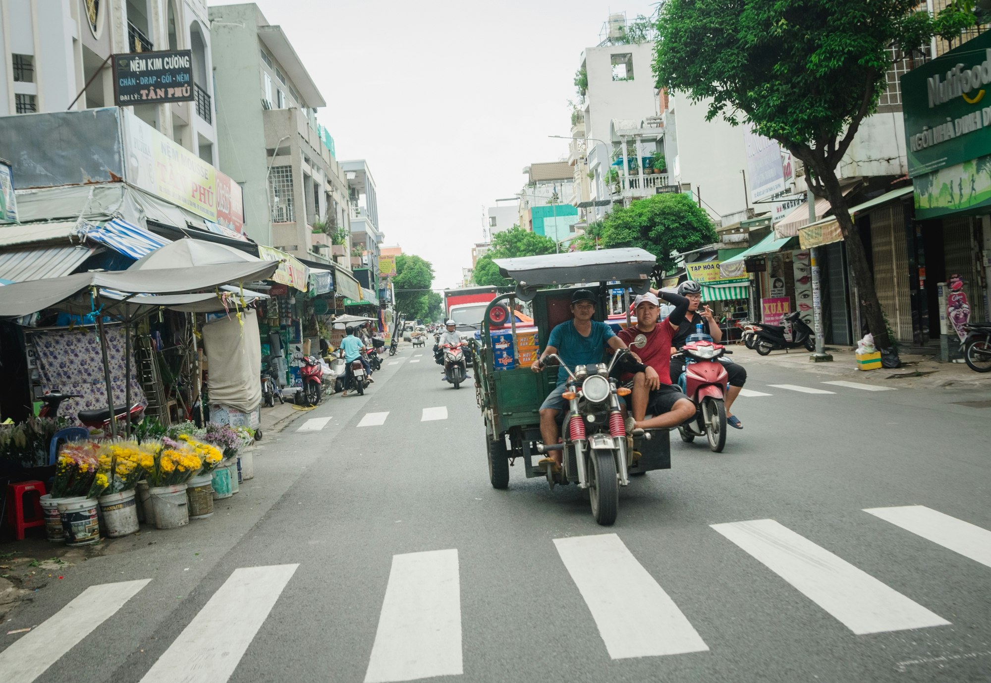 ベトナム・サイゴンの街路で走るバイクと屋台のある通りの風景