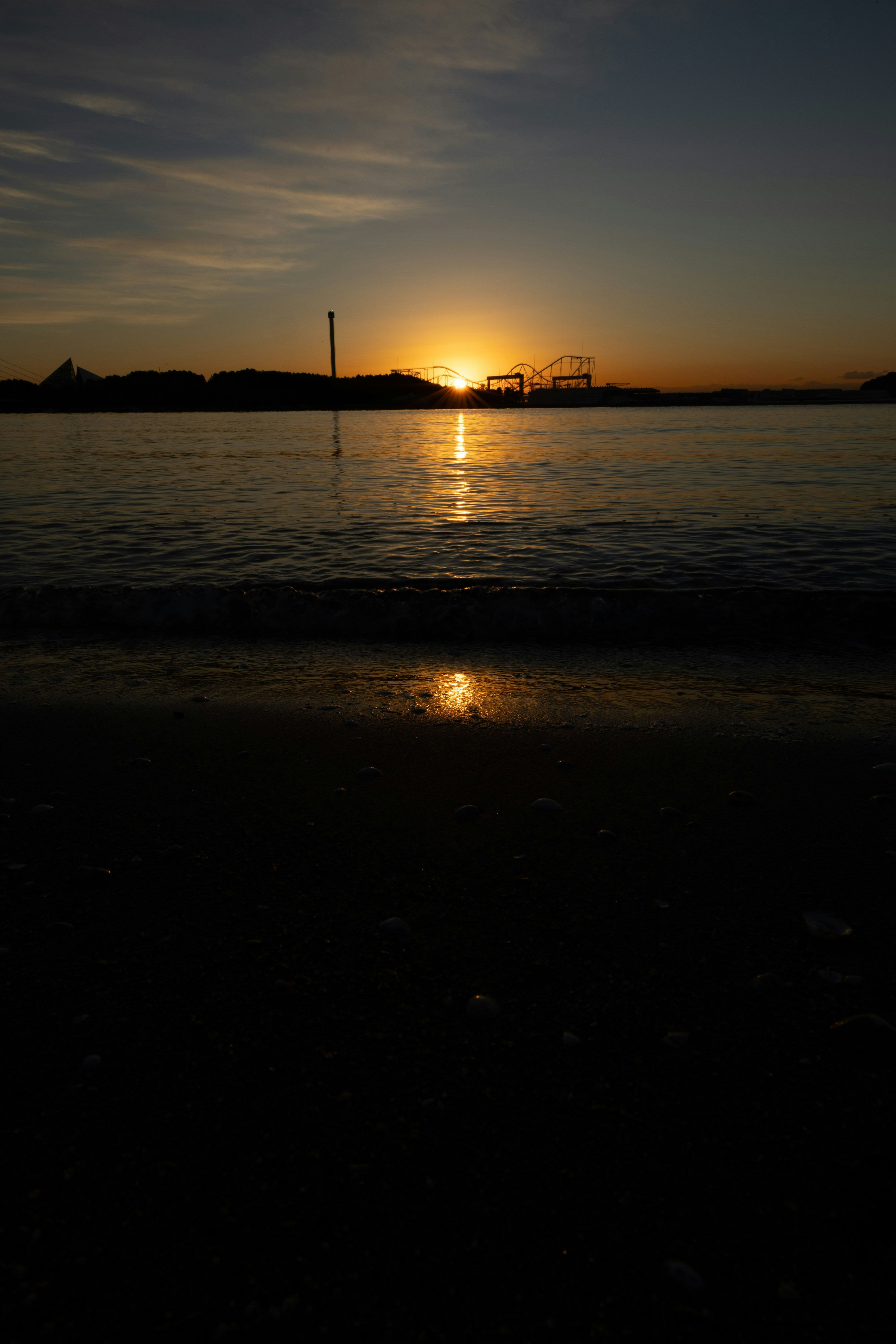 夕日に照らされる海面と遠景の橋