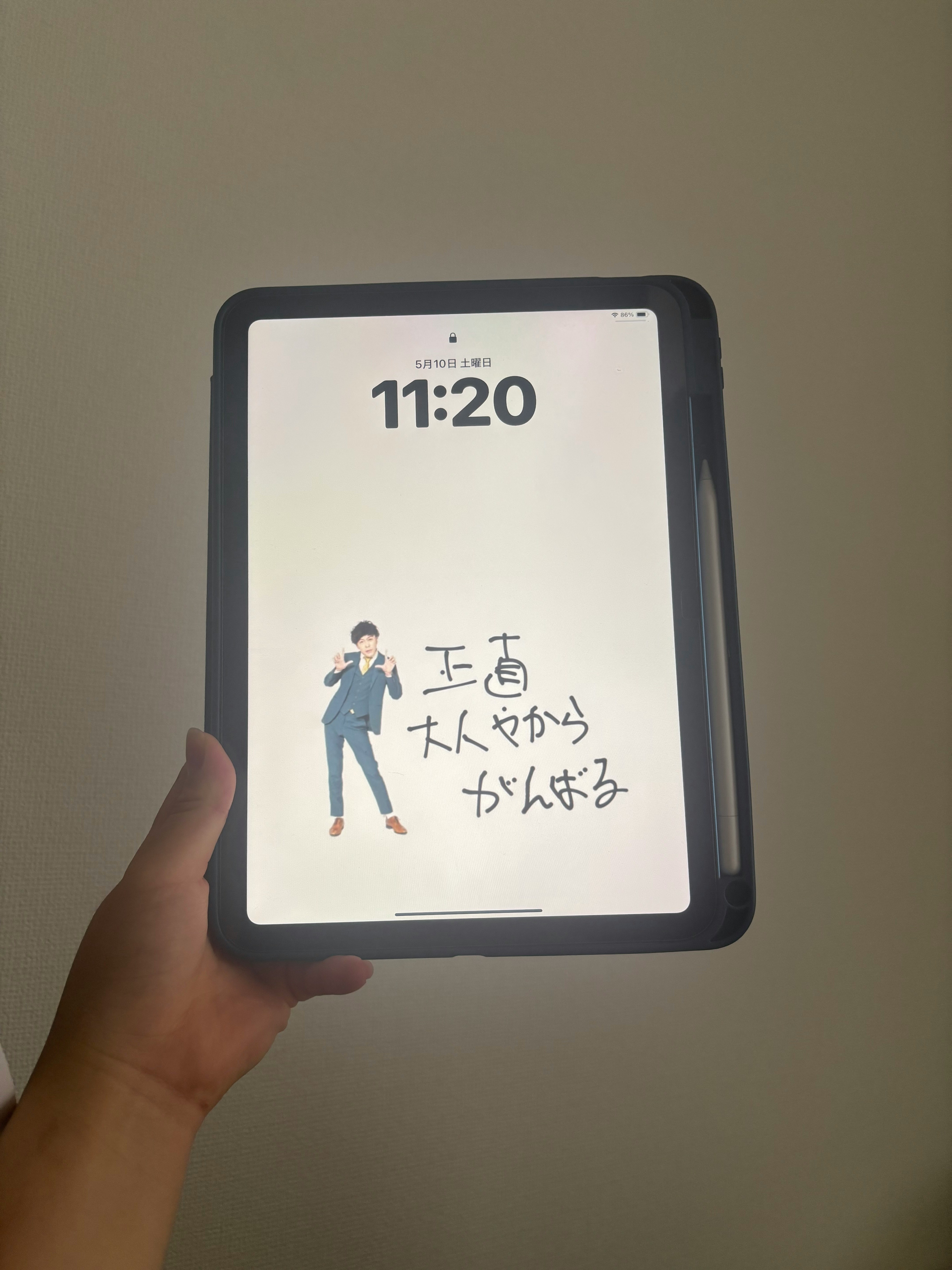 手に持ったスマホの画面に表示されたイラストと文字
