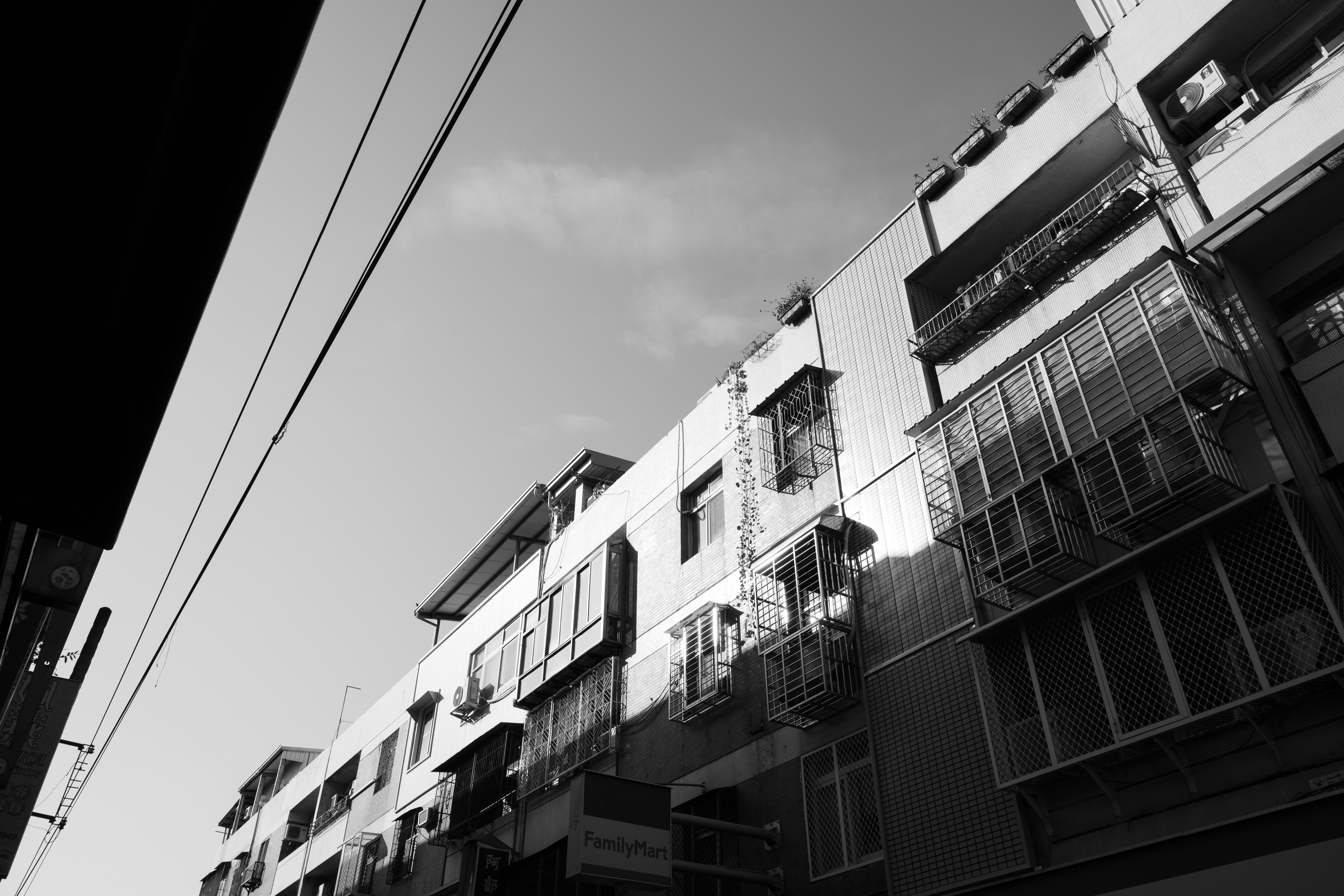 白黒の集合住宅の外壁とバルコニーが並ぶ建物の一部