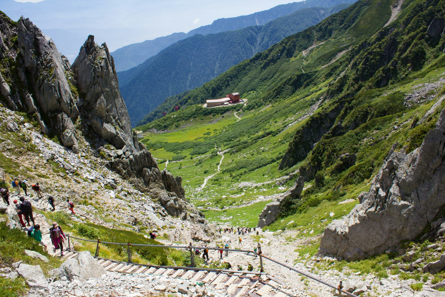 Malersiche Bergtal mit Wanderern auf dem Weg in der Ferne sichtbare Berghütte