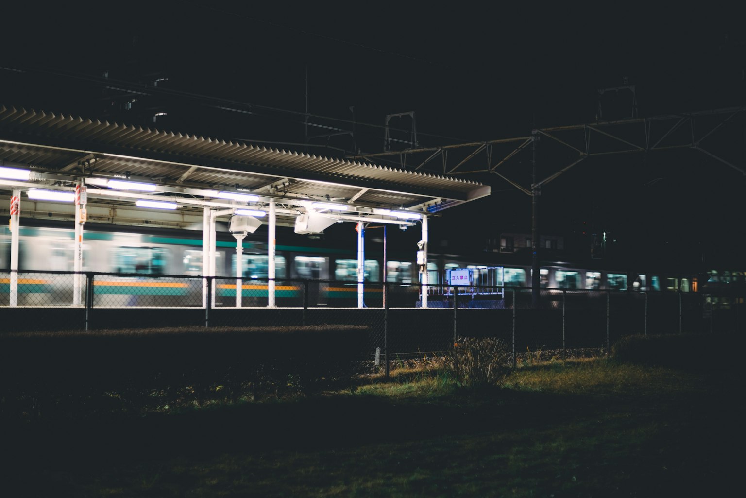 Train à la station nocturne avec flou de mouvement du train passant