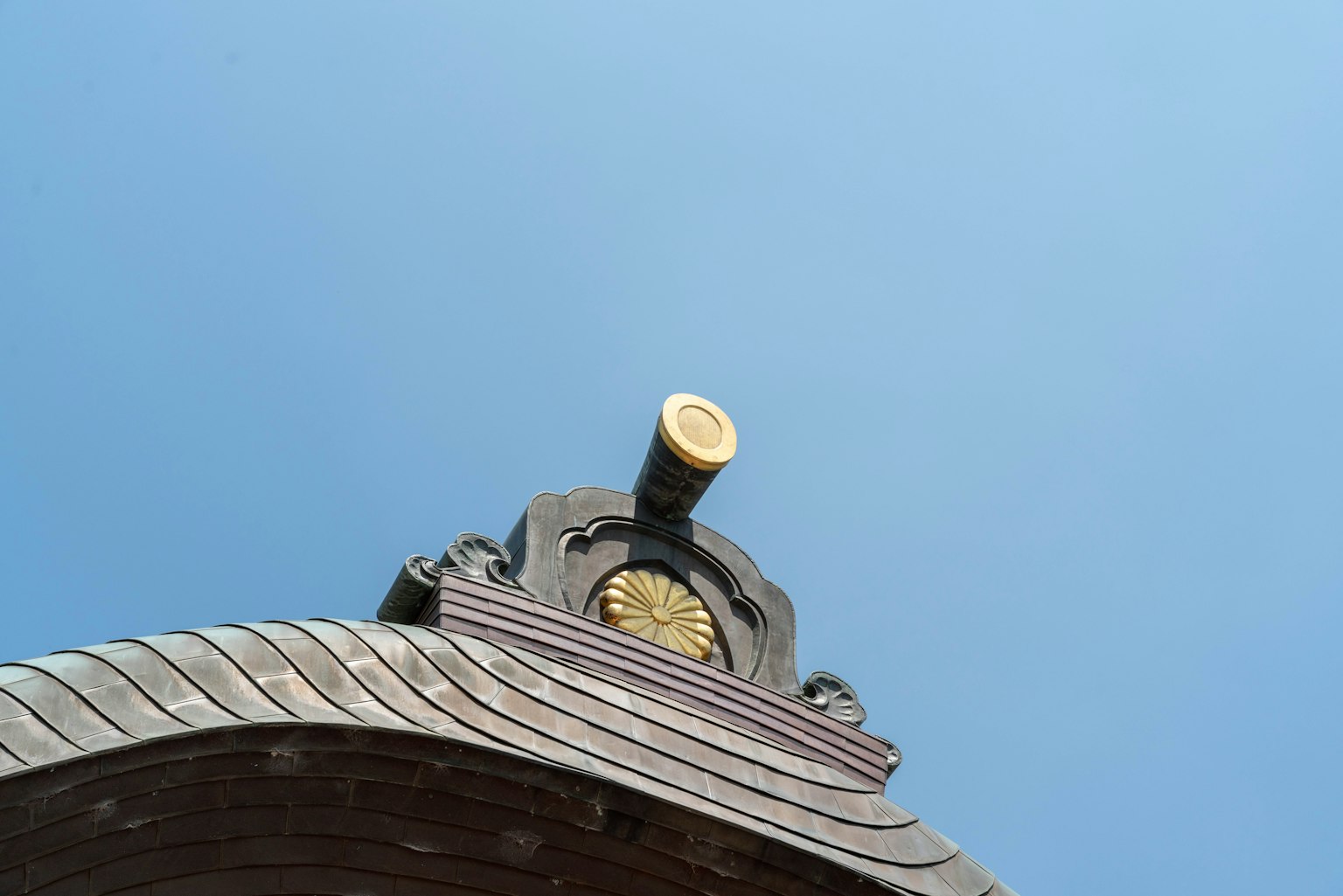 하늘을 배경으로 한 장식적인 지붕 세부 사항, 목각 조각, 금색 장식