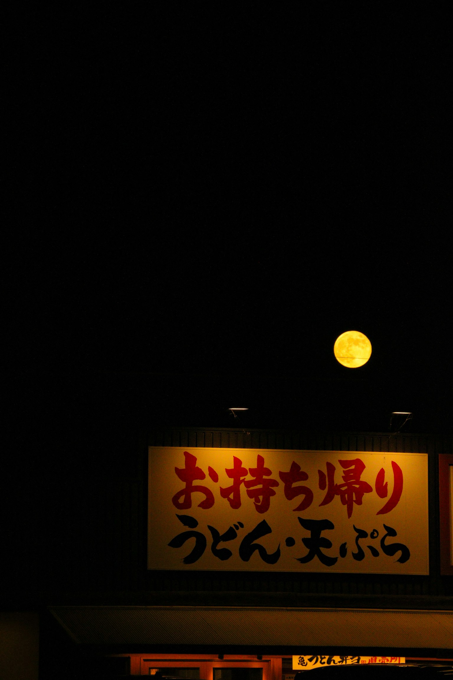 月亮照耀在日本烏冬面餐廳的招牌上