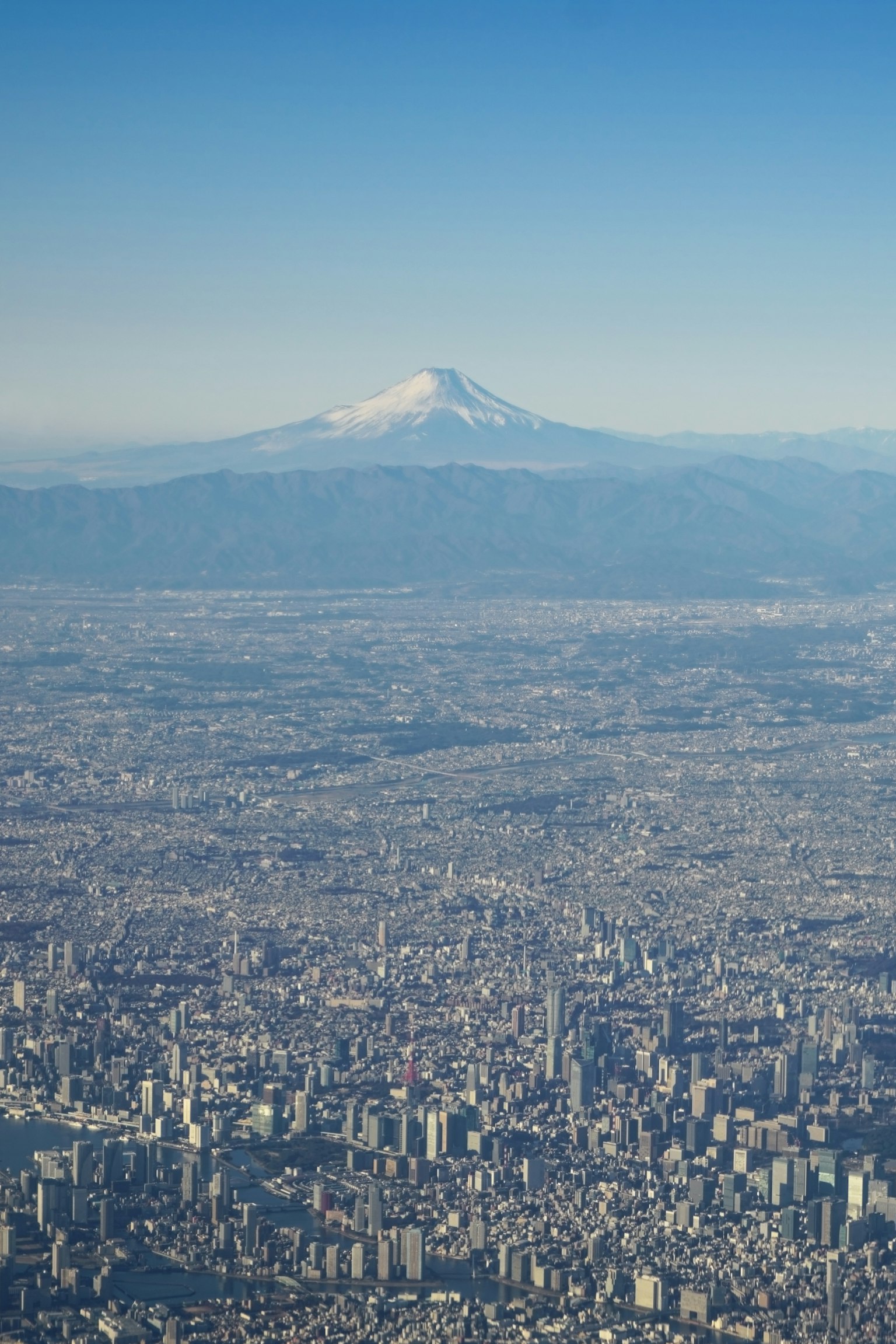 Luftaufnahme einer Stadt mit dem Fuji im Hintergrund