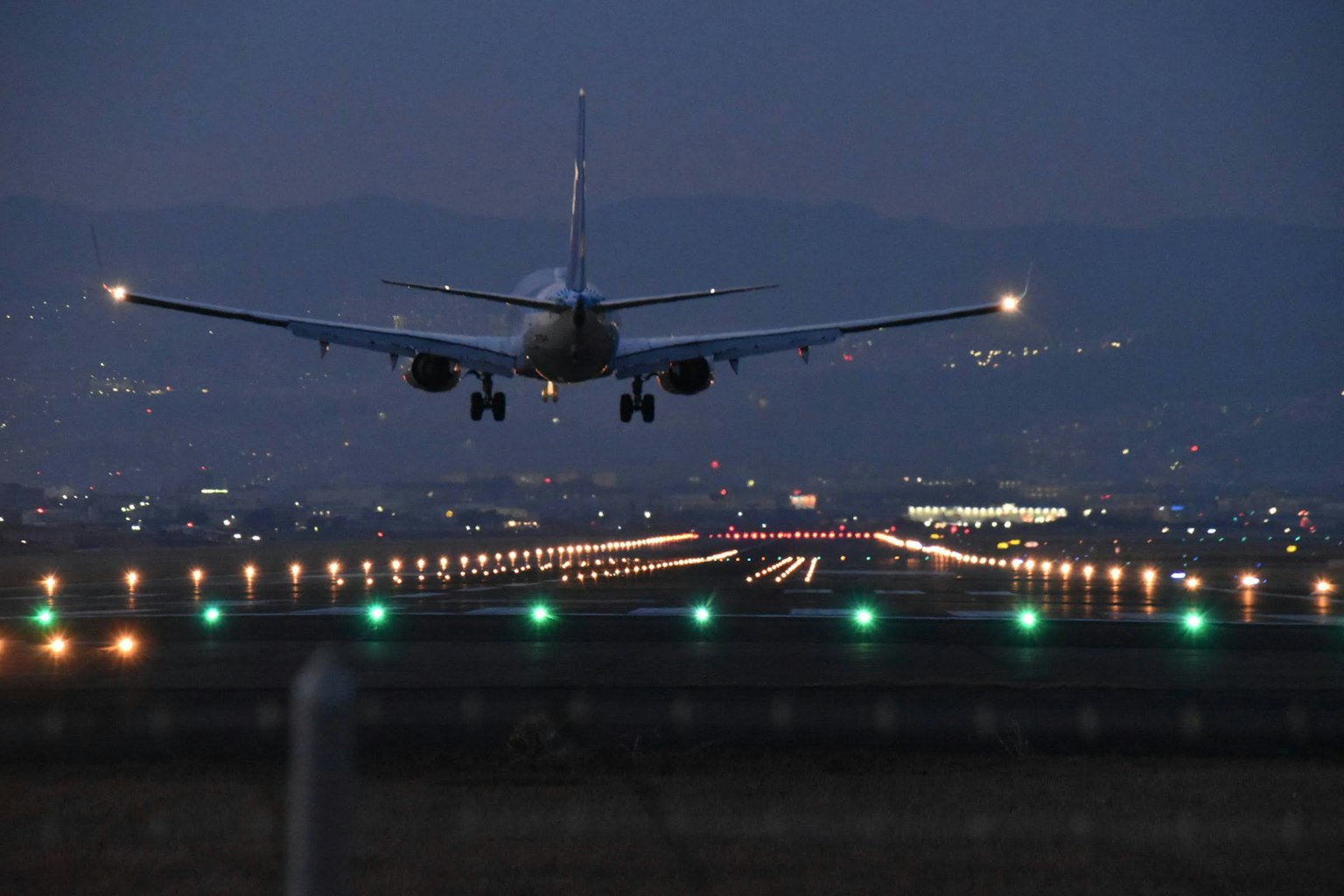 Avion atterrissant la nuit avec des lumières de piste illuminées