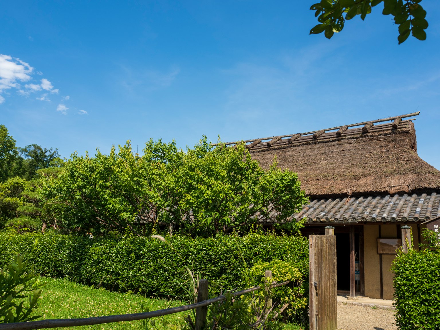 Traditionelles japanisches Haus umgeben von üppigem Grün blauer Himmel und weiße Wolken