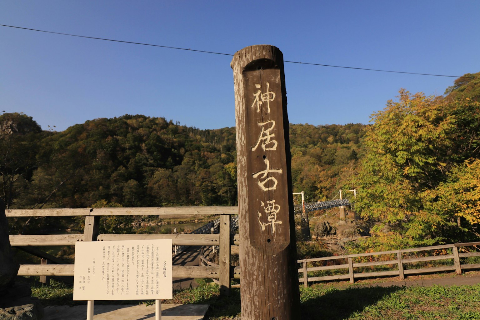 Holzschild von Kamui Kotan mit umliegender Naturlandschaft
