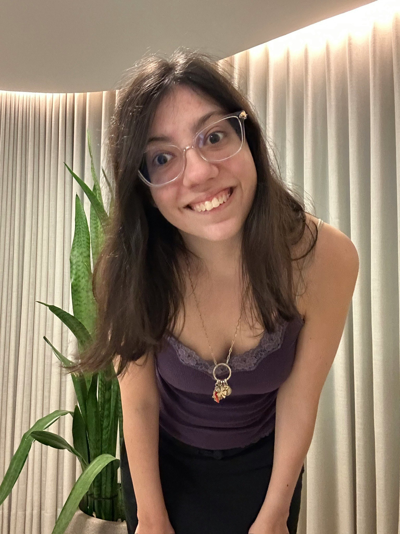 観葉植物のそばで微笑む女性のポートレート