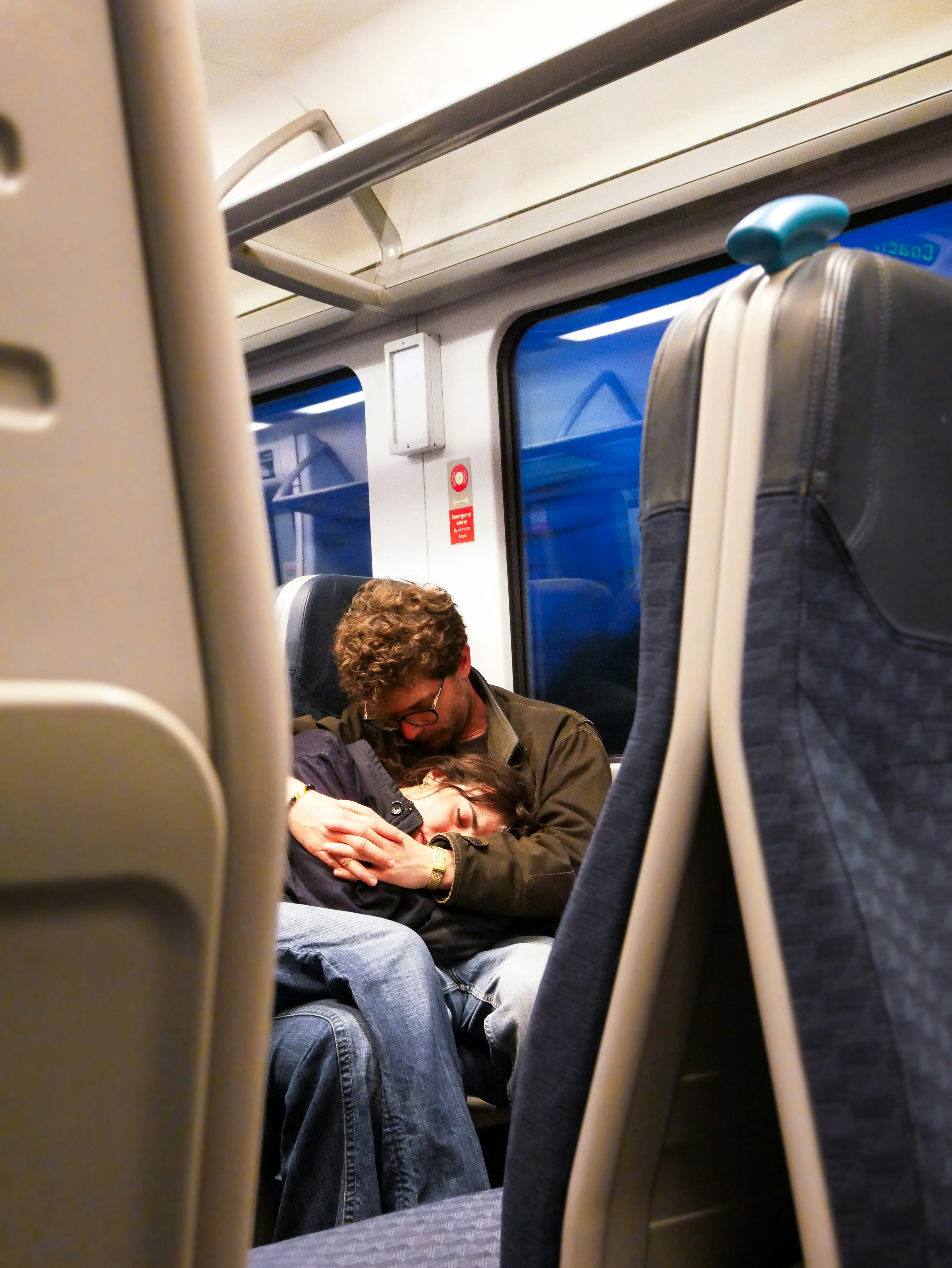 電車の車内で寄り添う恋人とピザ箱を抱える人