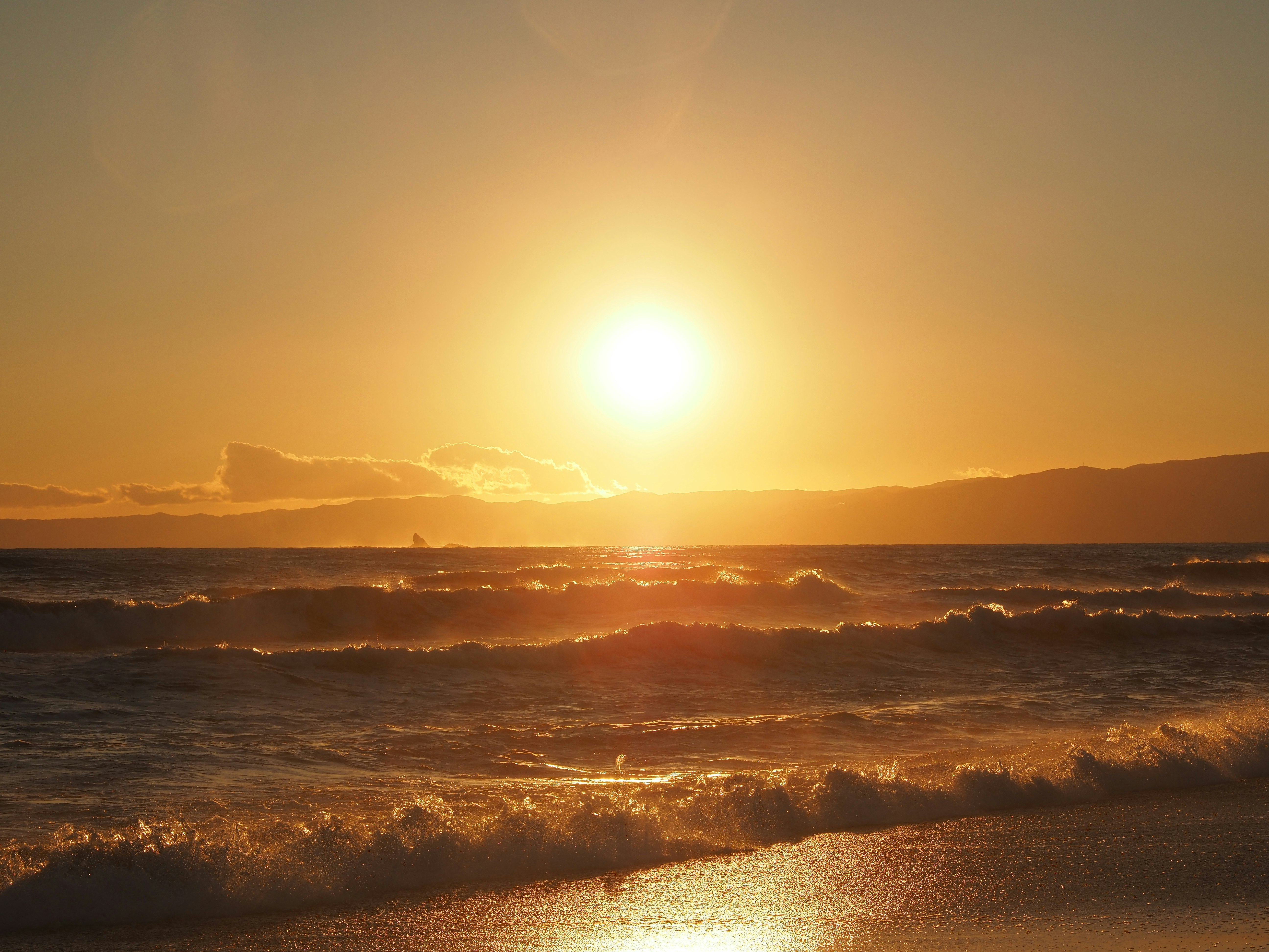 seaside landscape with sunset glow, mist and waves