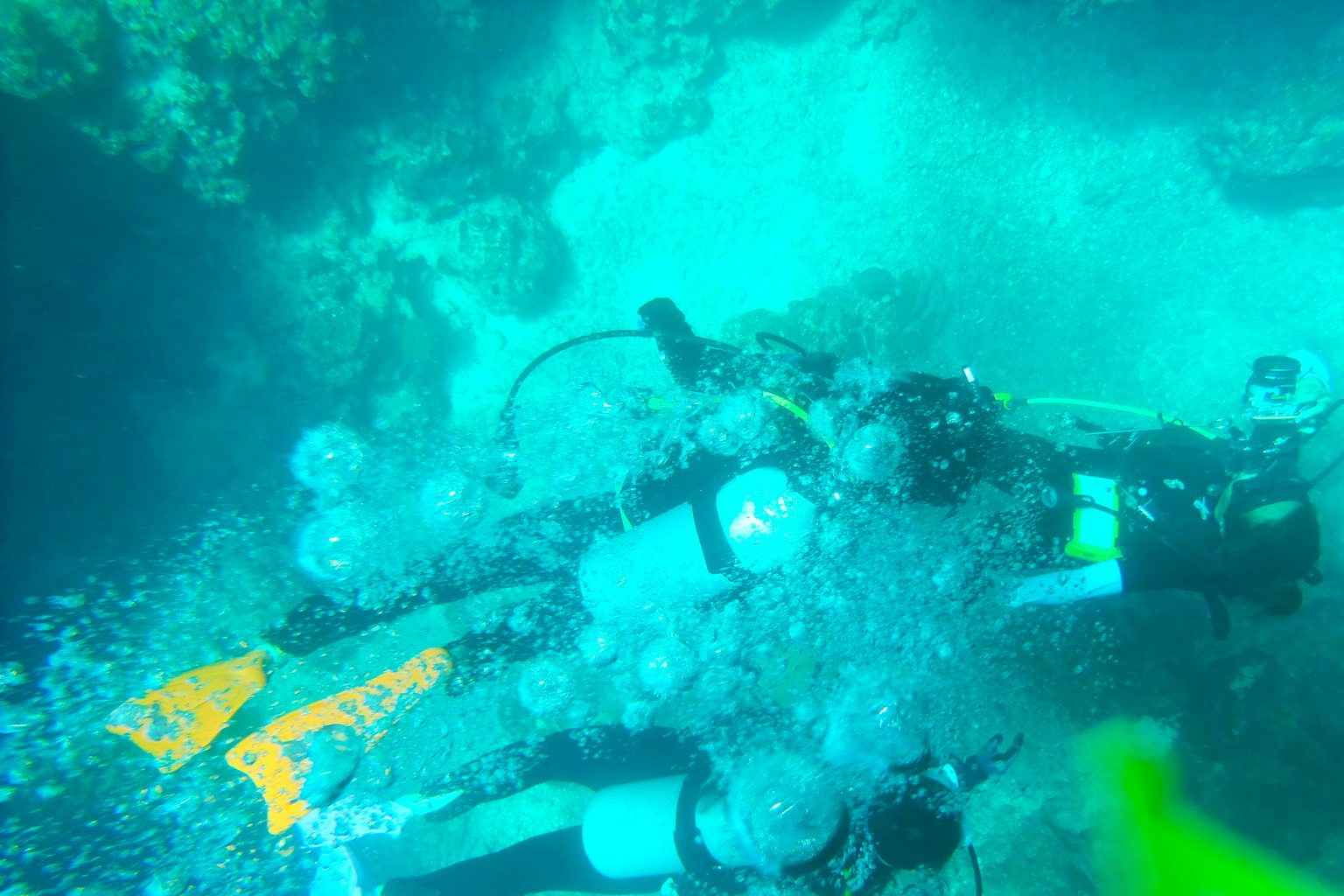 Penyelam di bawah air dikelilingi gelembung dalam pemandangan laut biru