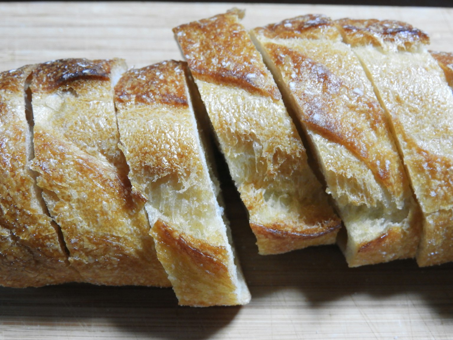 Baguette tranchée reposant sur une planche en bois