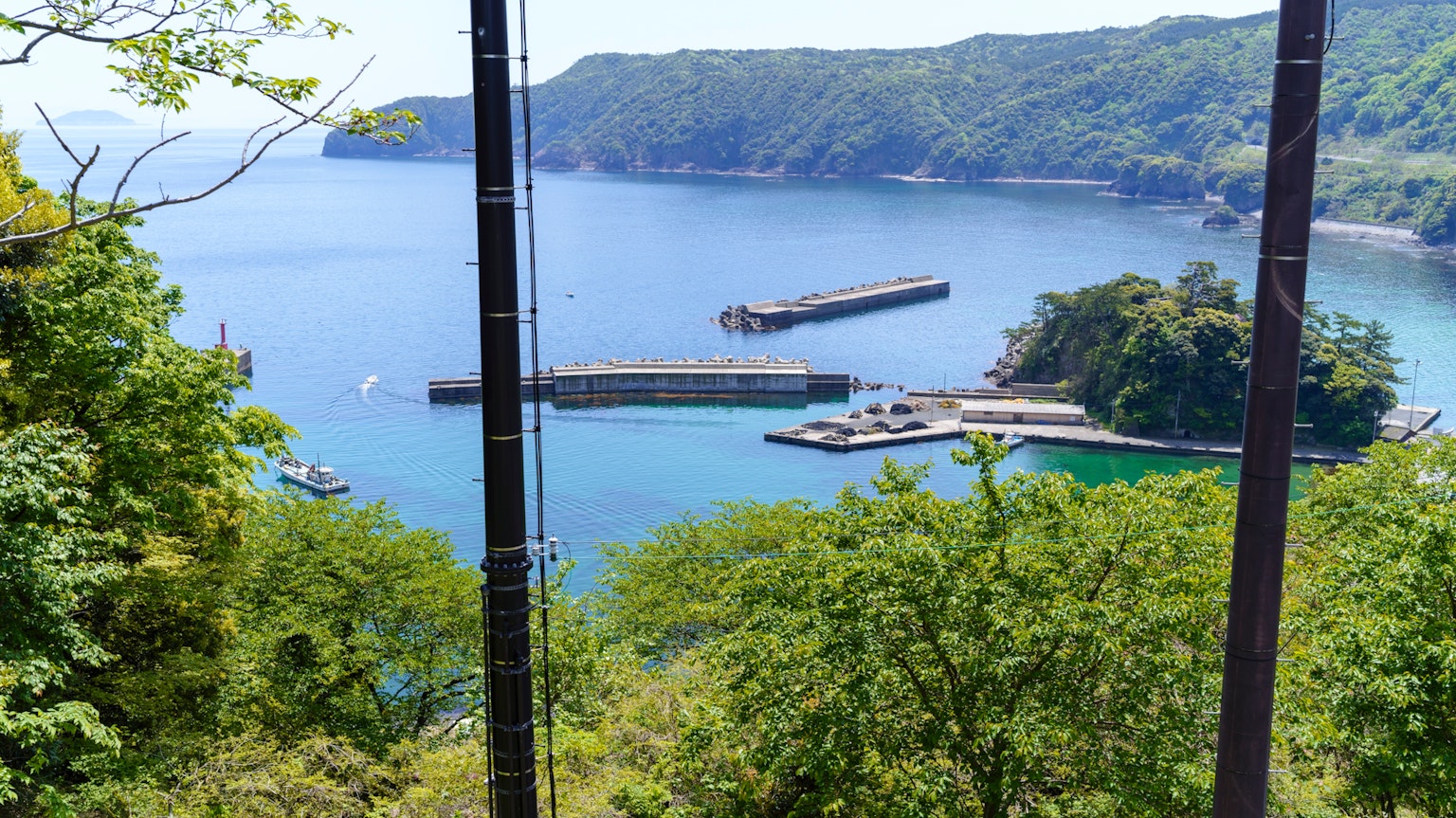Vista panoramica del mare con montagne verdi e un porto