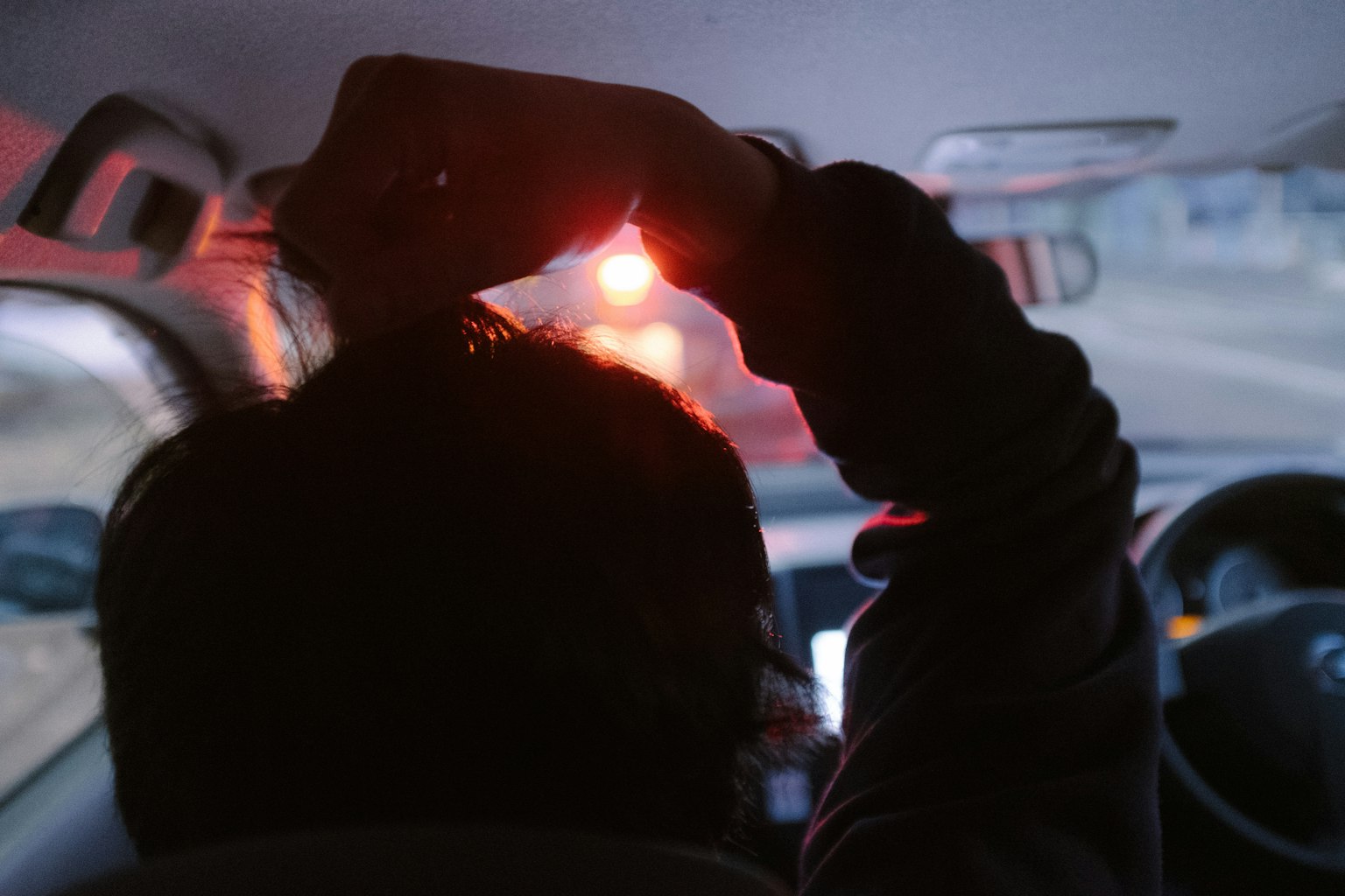 Person, die im Auto die Haare mit rotem Licht richtet