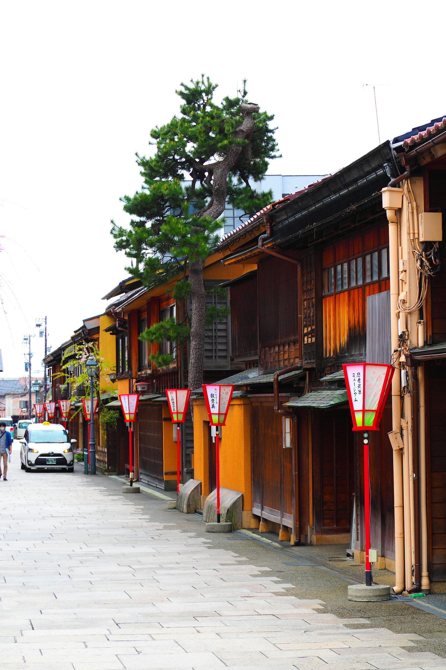 Une rue calme bordée de bâtiments en bois traditionnels avec des lanternes rouges