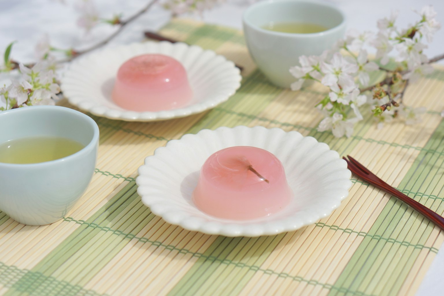 Dulces japoneses rosas servidos con té y flores de cerezo