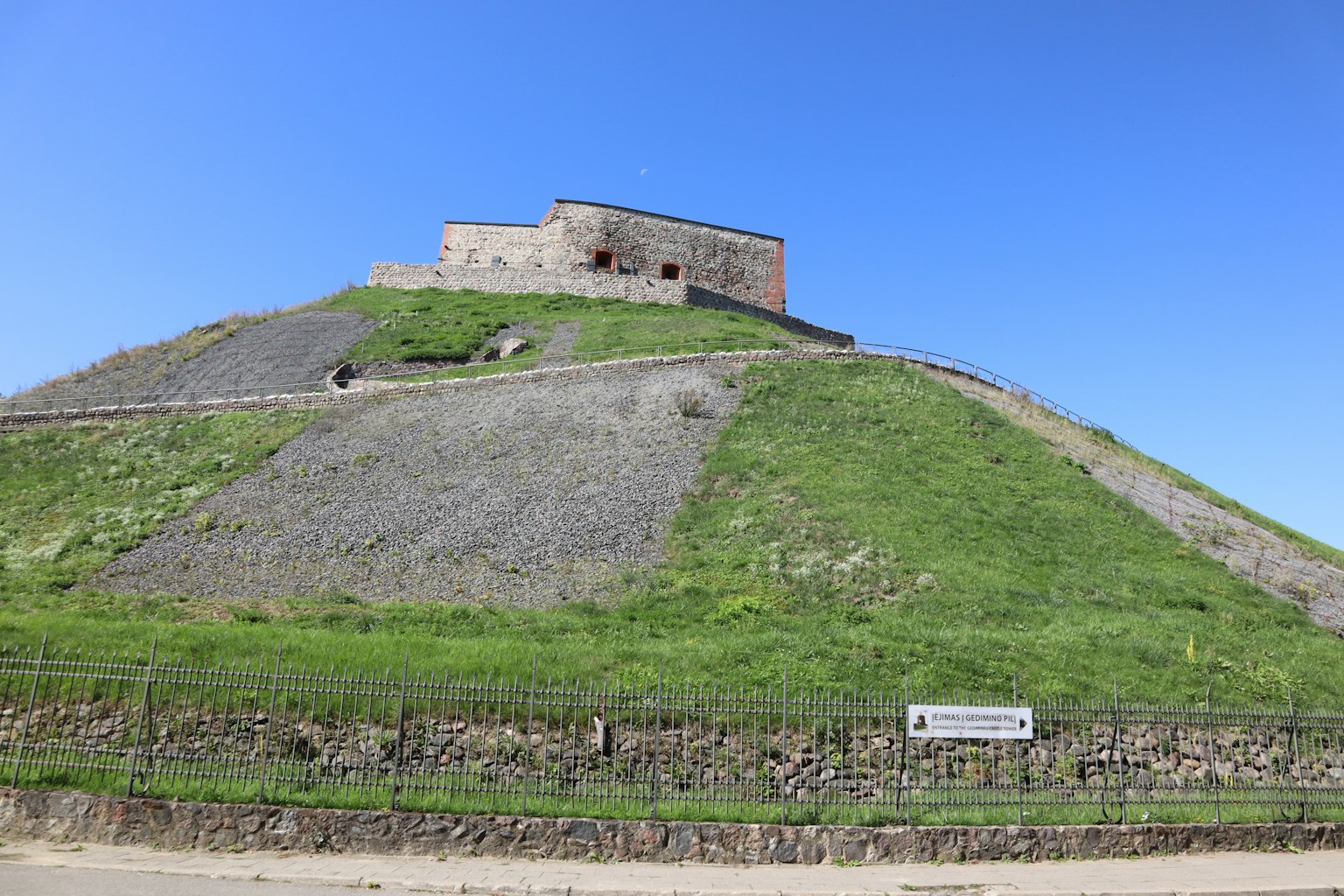 Structure ancienne sur une colline verte sous un ciel bleu