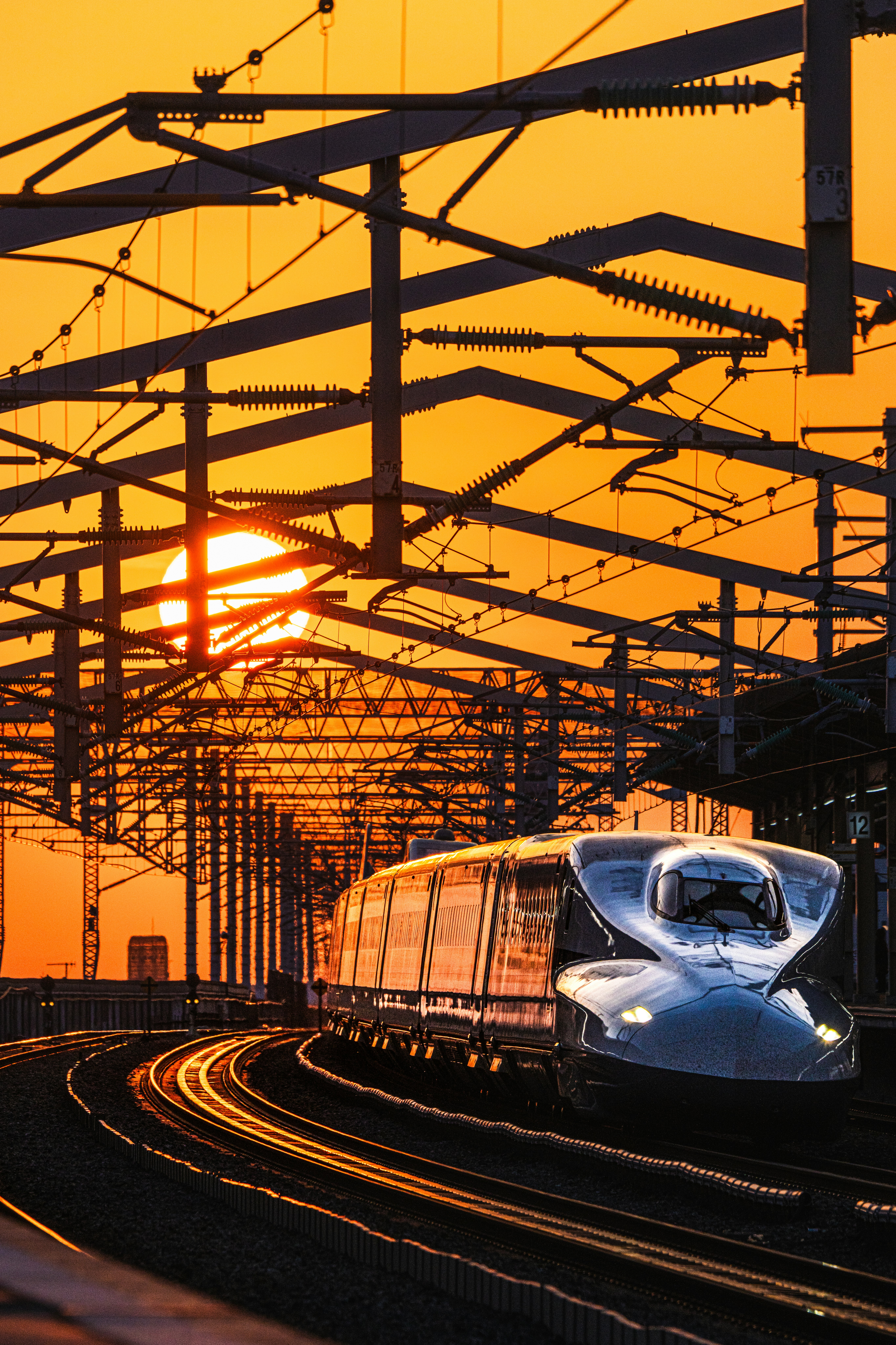 夕焼けの線路を走る新幹線の車両