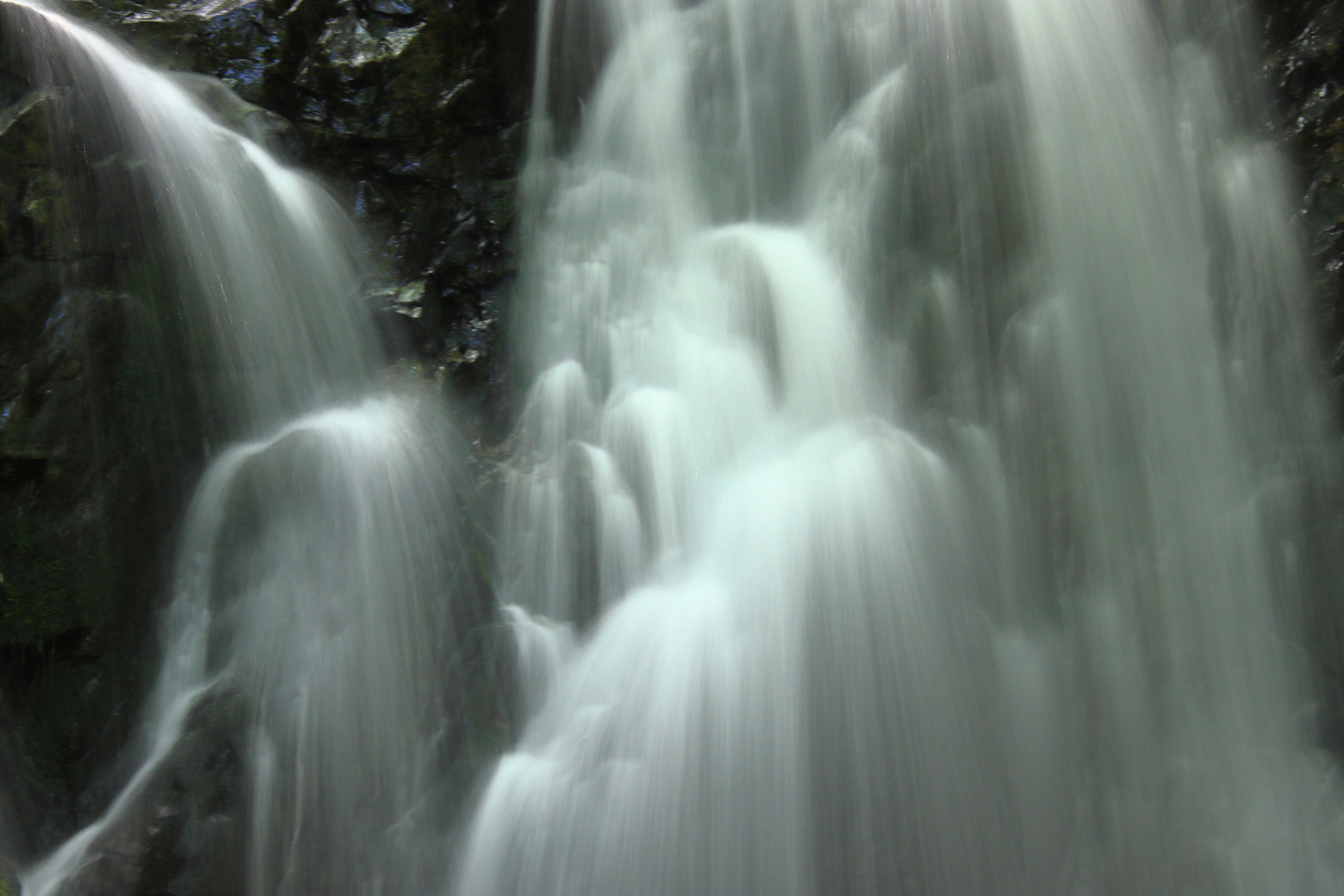 Pemandangan indah air terjun yang mengalir di atas batu