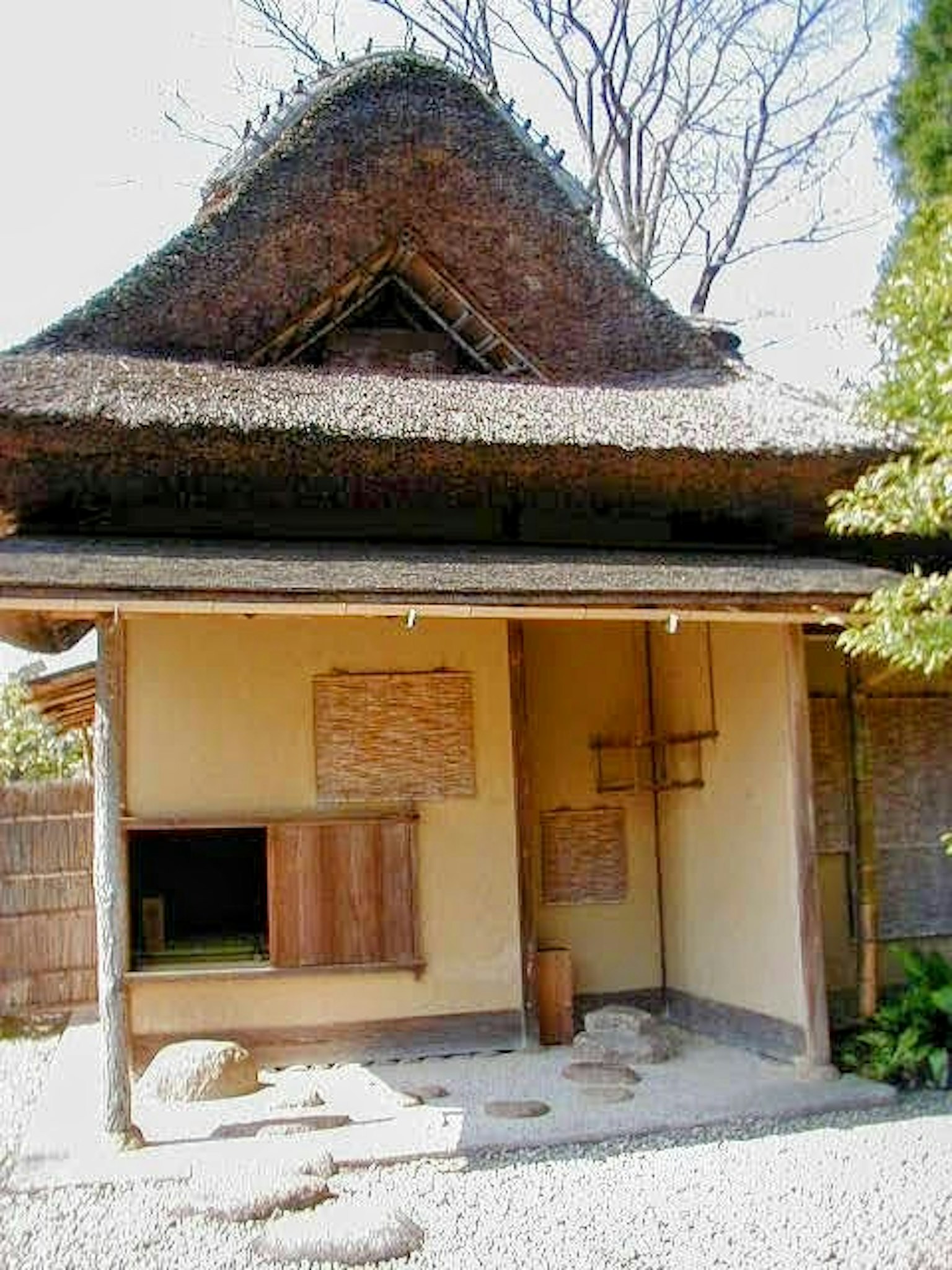 Eksterior rumah tradisional Jepang dengan atap jerami dan dinding tanah
