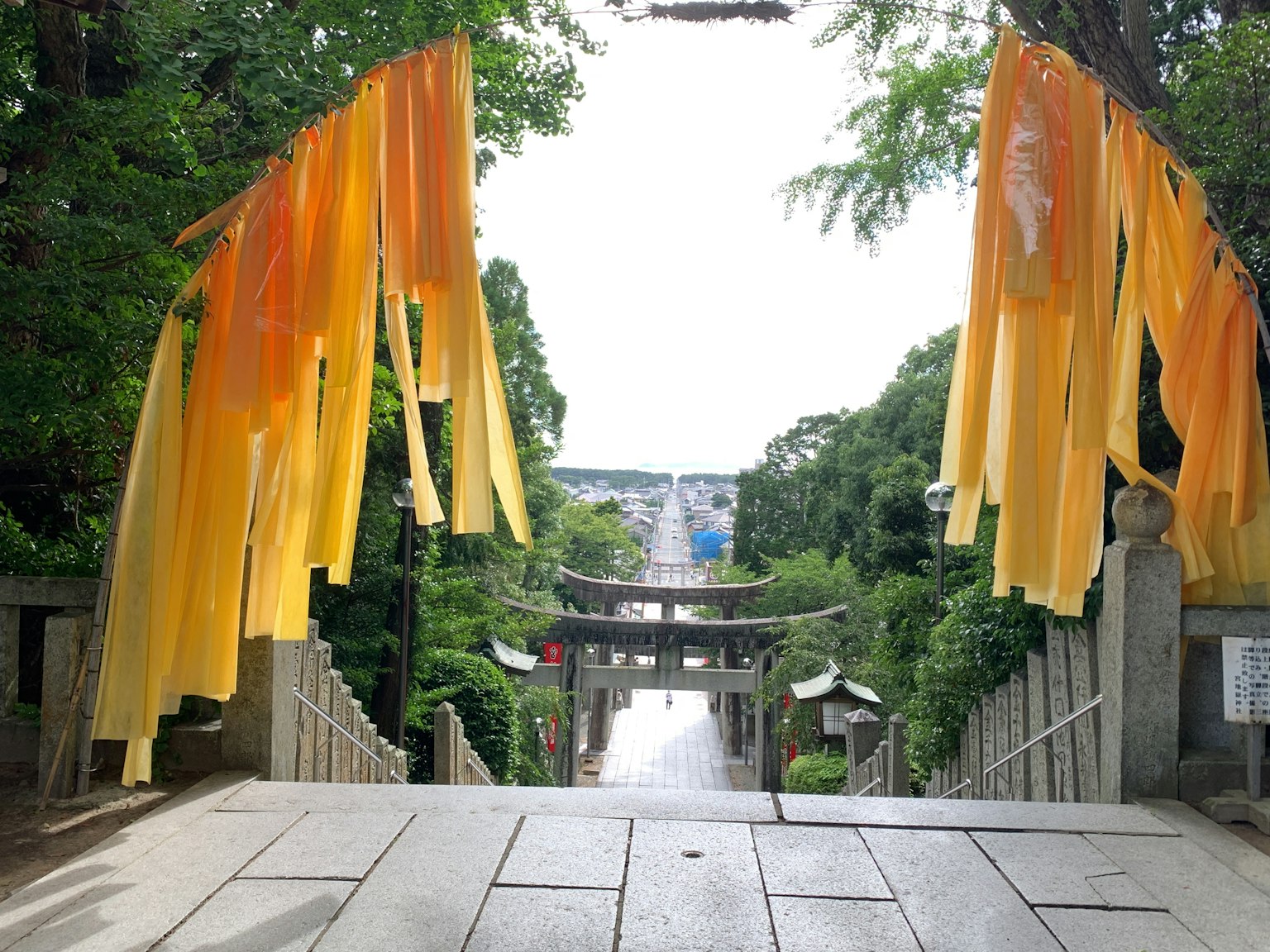View from the entrance of a shrine with yellow fabric hanging and a pathway leading into the distance