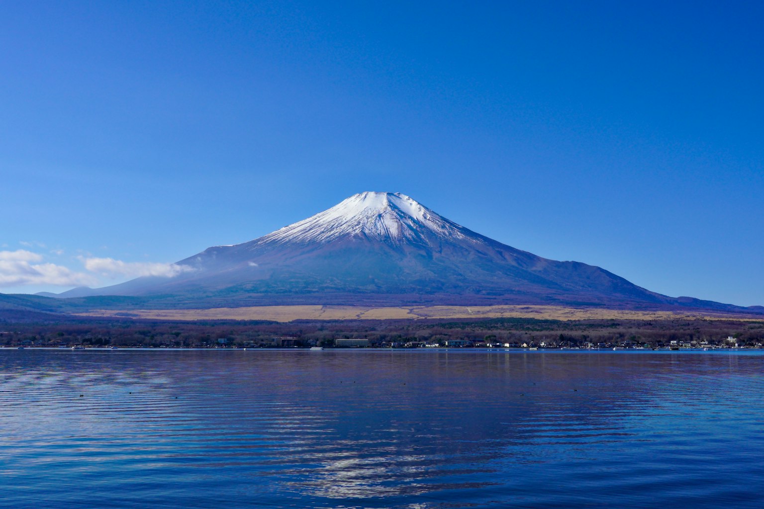 Il monte Fuji che si erge sotto un cielo blu chiaro riflesso nel lago