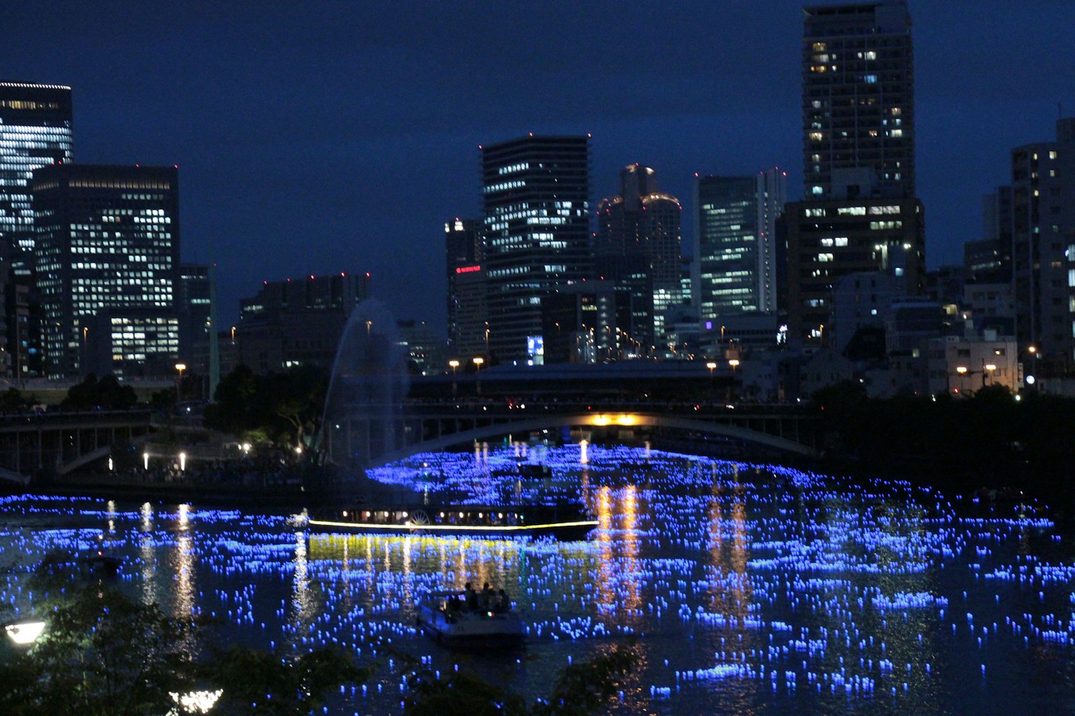 Paesaggio urbano notturno che riflette luci blu sull'acqua