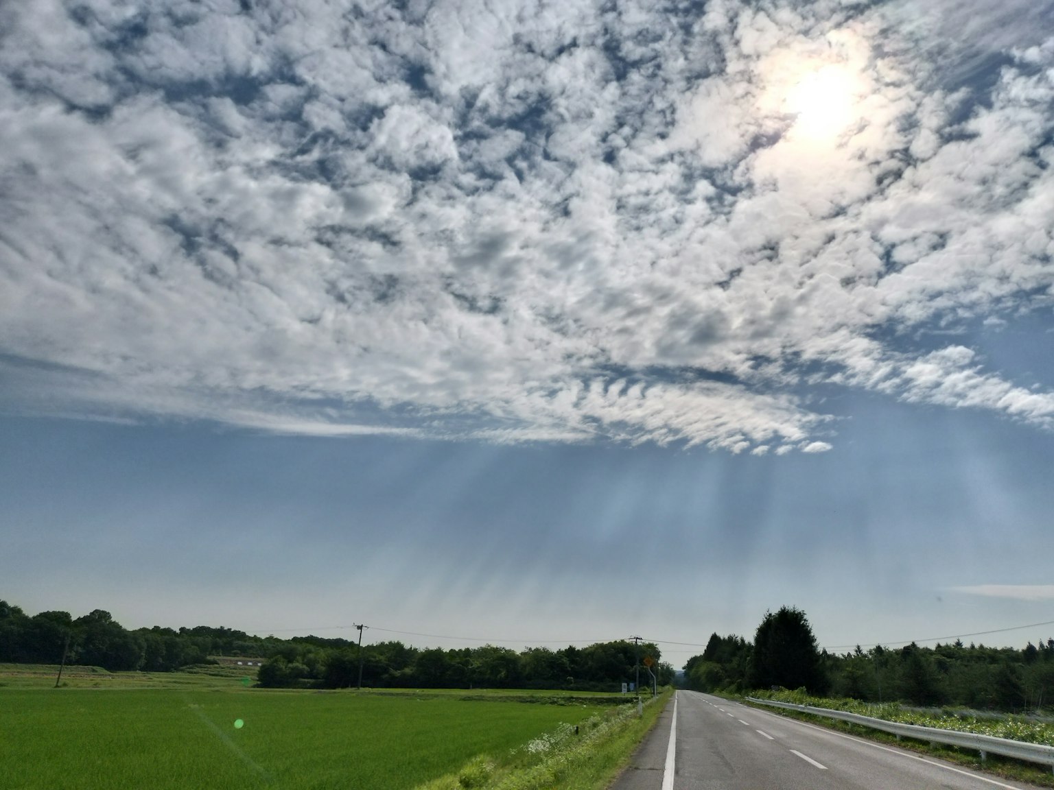 Malersiche Sicht auf blauen Himmel mit weißen Wolken und grünem Land