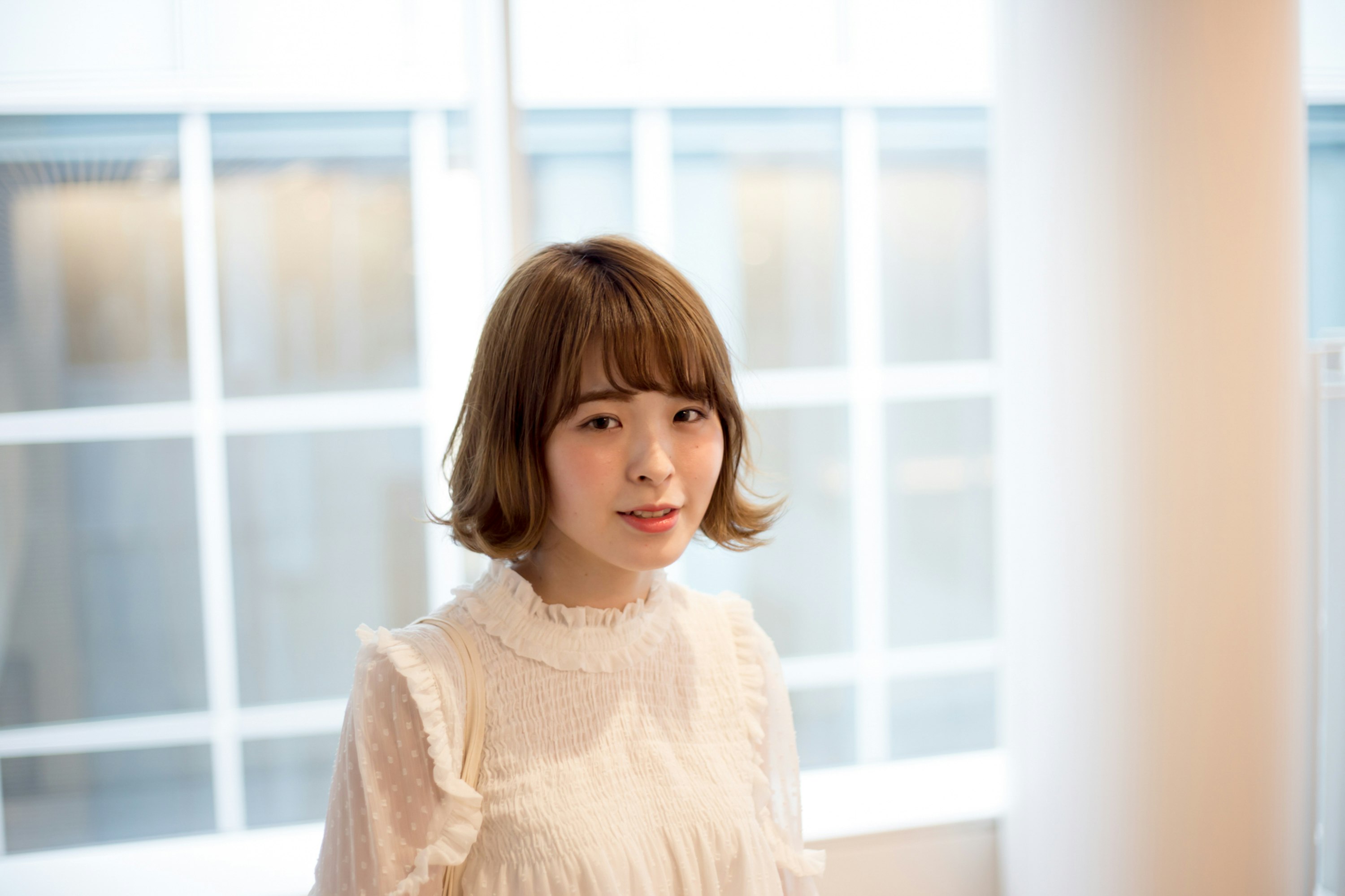 woman standing in front of a white grid window