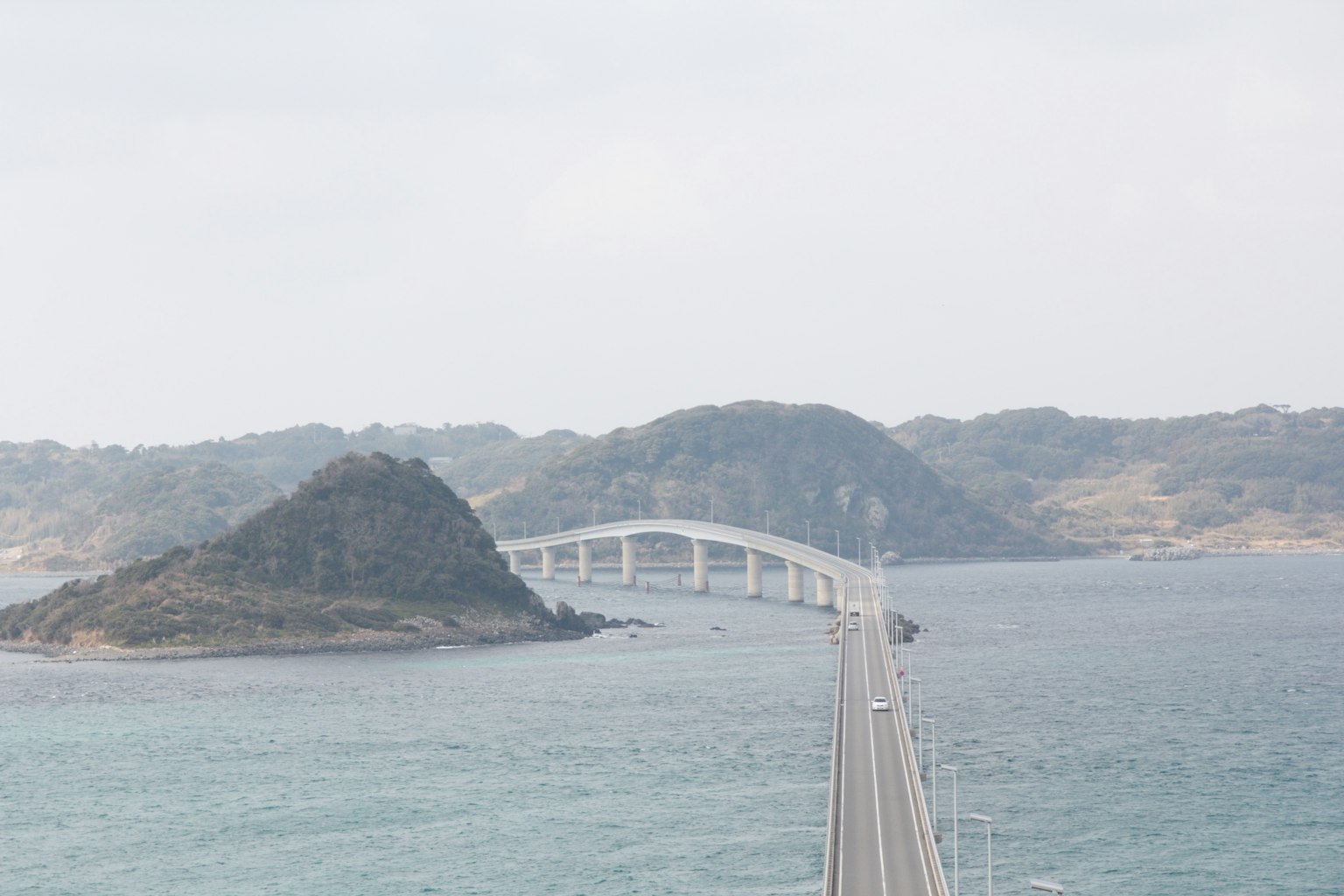 Scenic view of a bridge over the sea with an island