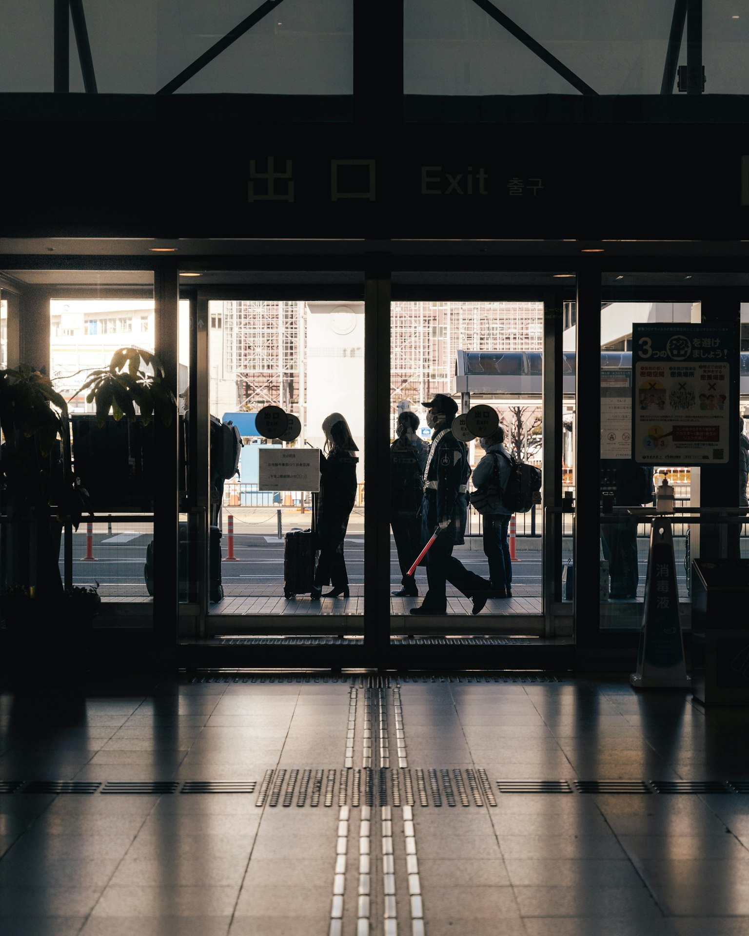 Des personnes marchant à travers l'entrée d'une gare
